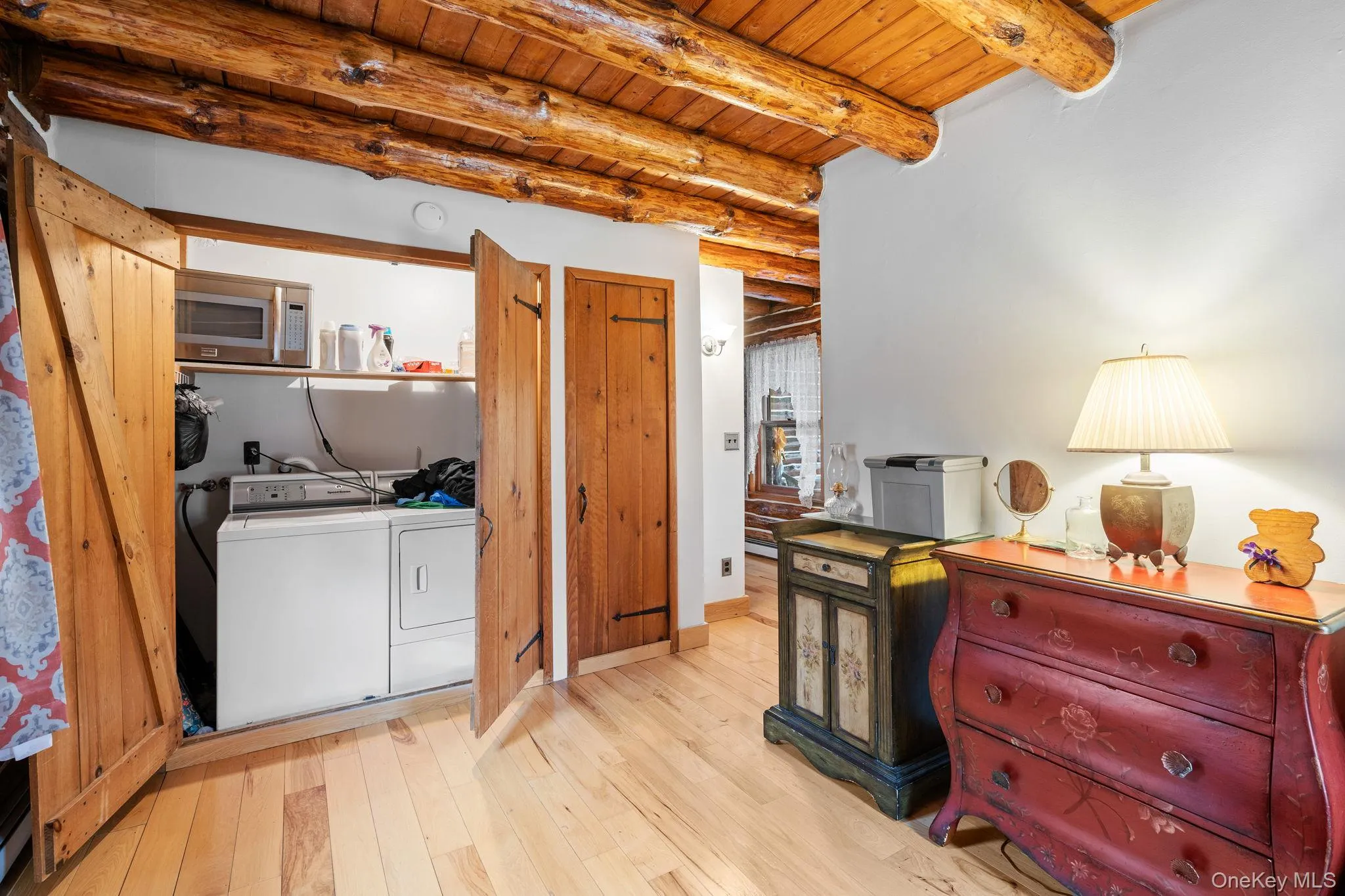 Washroom featuring washer and clothes dryer, wooden ceiling, and hardwood / wood-style flooring Washroom featuring washer and clothes dryer, wooden ceiling, and hardwood / wood-style flooring
