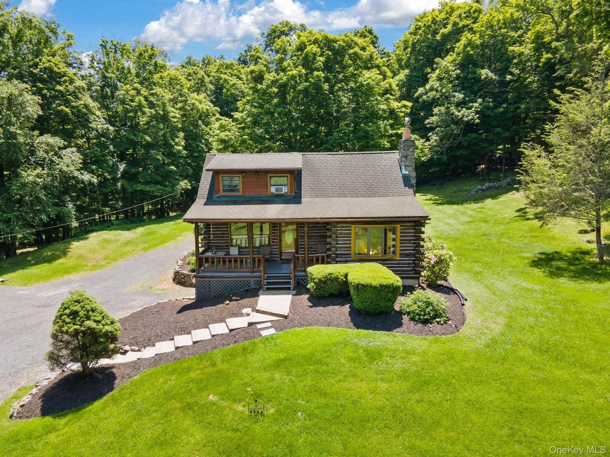 Log cabin with log siding, a porch, a front yard, and a chimney Log cabin with log siding, a porch, a front yard, and a chimney