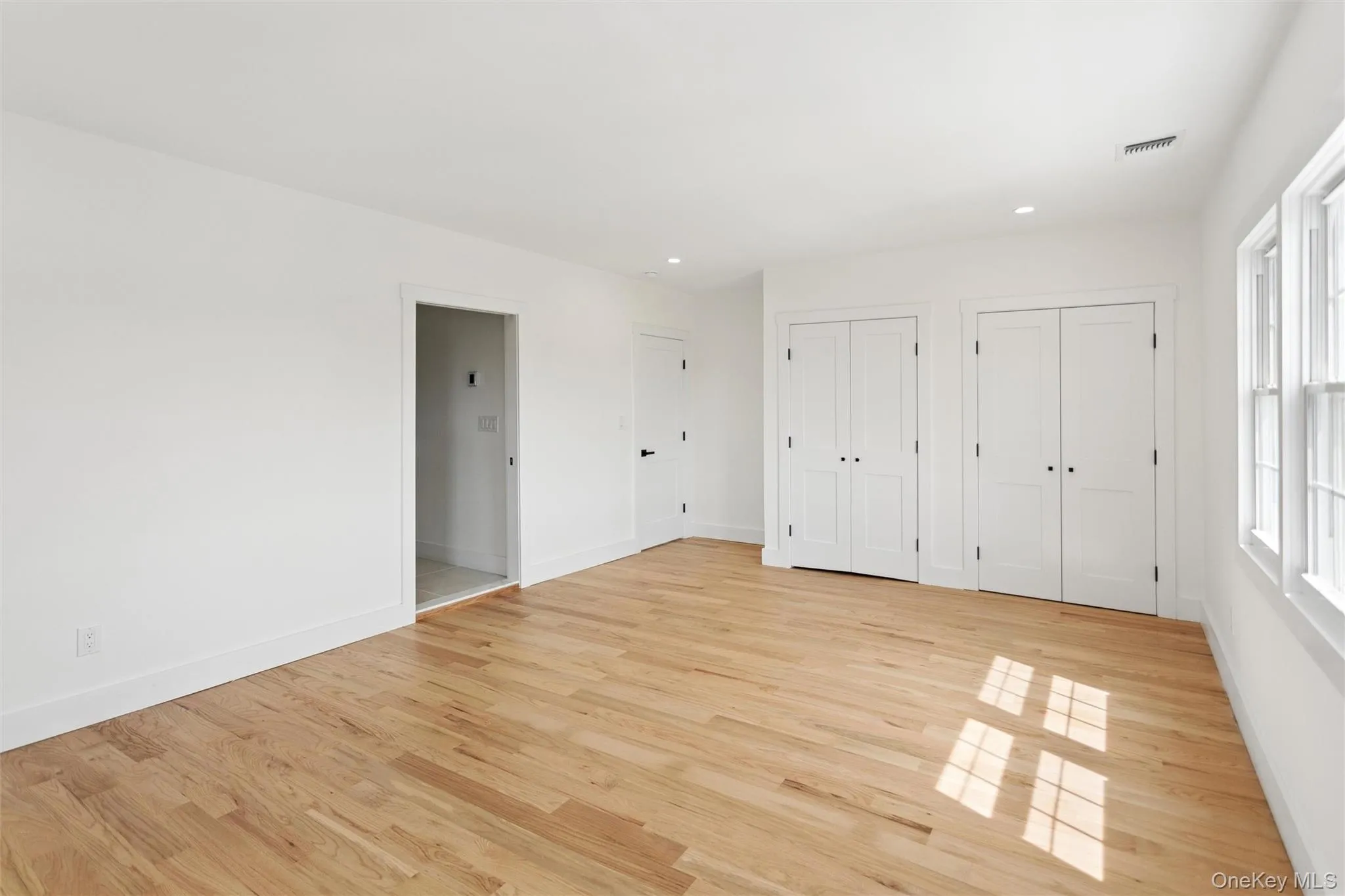 This room features light hardwood floors, white walls, and white trim This room features light hardwood floors, white walls, and white trim