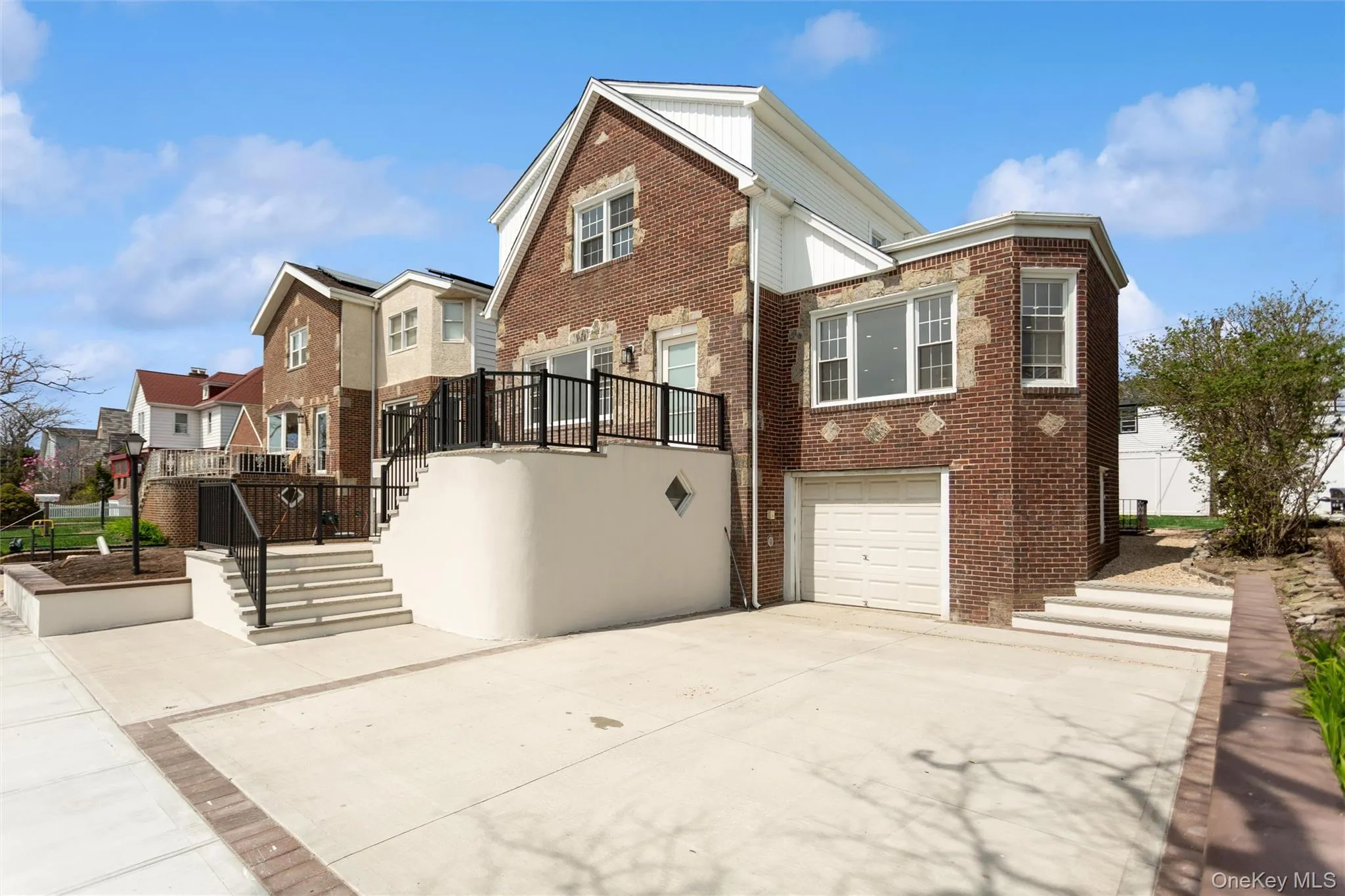 The property features a brick exterior with stone accents, a concrete driveway, and an integrated garage The property features a brick exterior with stone accents, a concrete driveway, and an integrated garage
