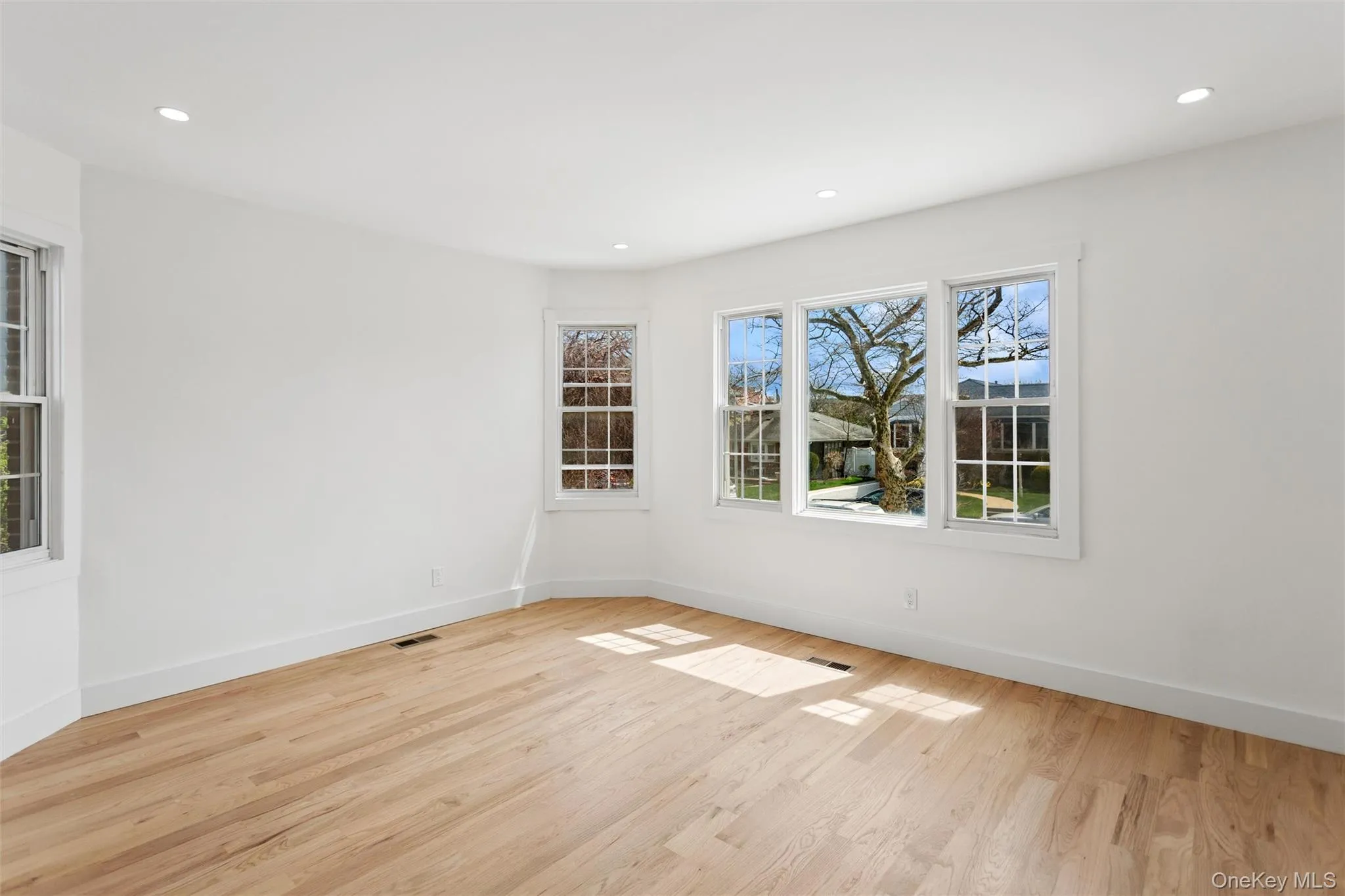 This bright room features light hardwood floors, white walls, and recessed lighting This bright room features light hardwood floors, white walls, and recessed lighting
