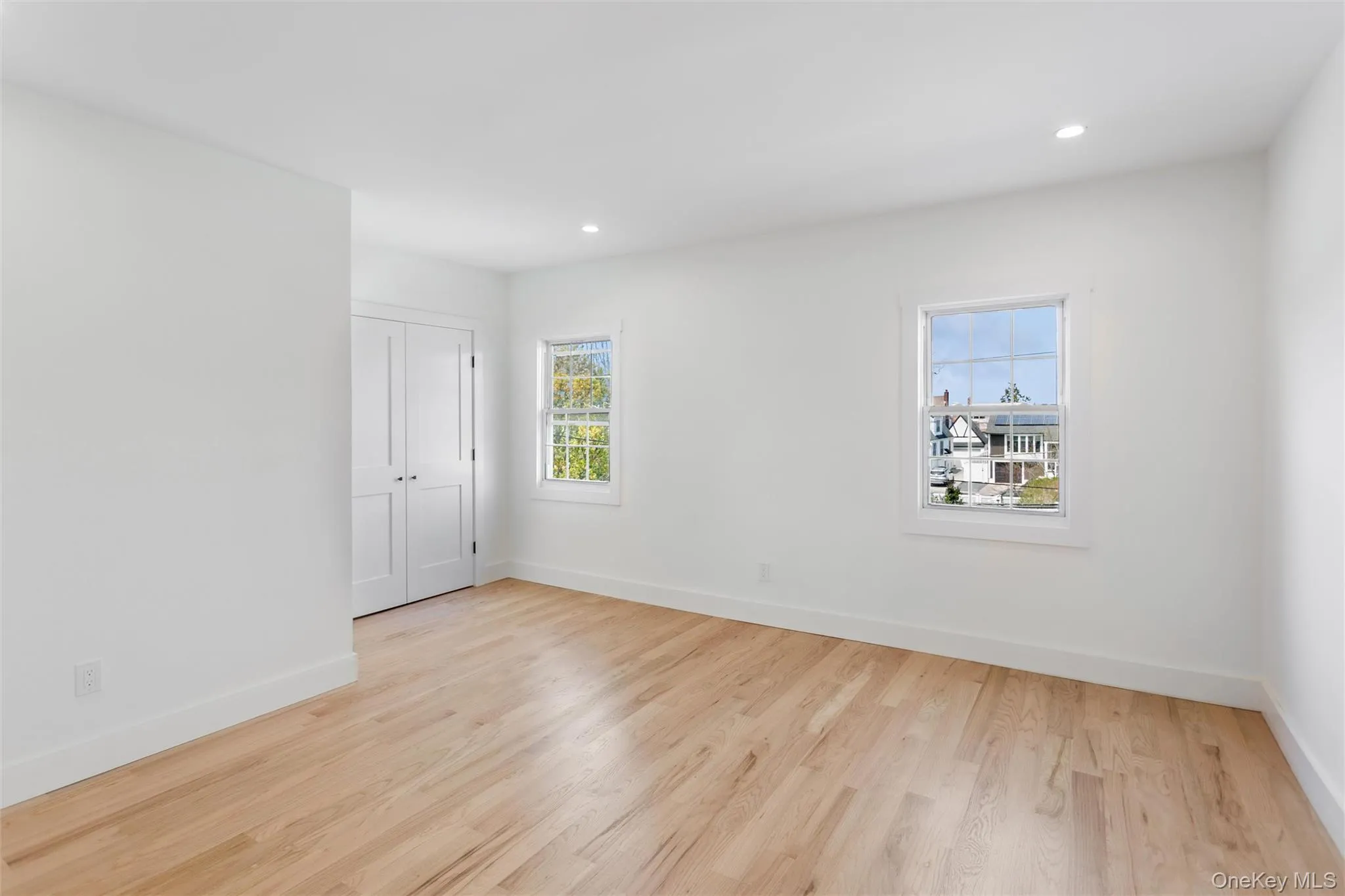 The room features light wood flooring, white walls, and recessed lighting The room features light wood flooring, white walls, and recessed lighting