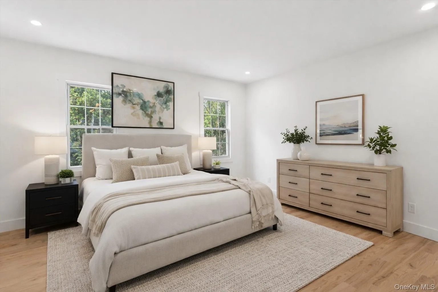 Staged Photo This bedroom features light wood flooring and white walls, creating a bright and airy atmosphere Staged Photo This bedroom features light wood flooring and white walls, creating a bright and airy atmosphere