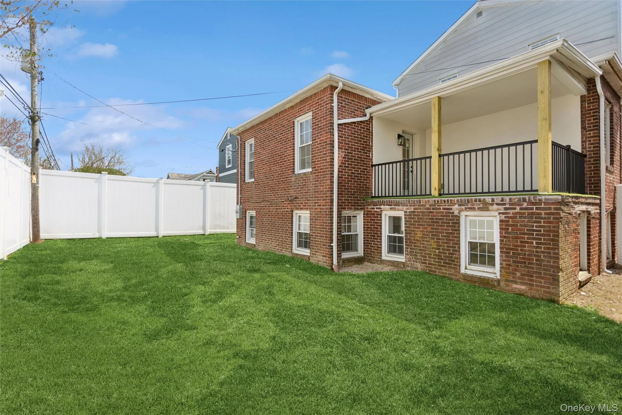 The property features a well-maintained lawn, a white privacy fence, and a brick exterior The property features a well-maintained lawn, a white privacy fence, and a brick exterior
