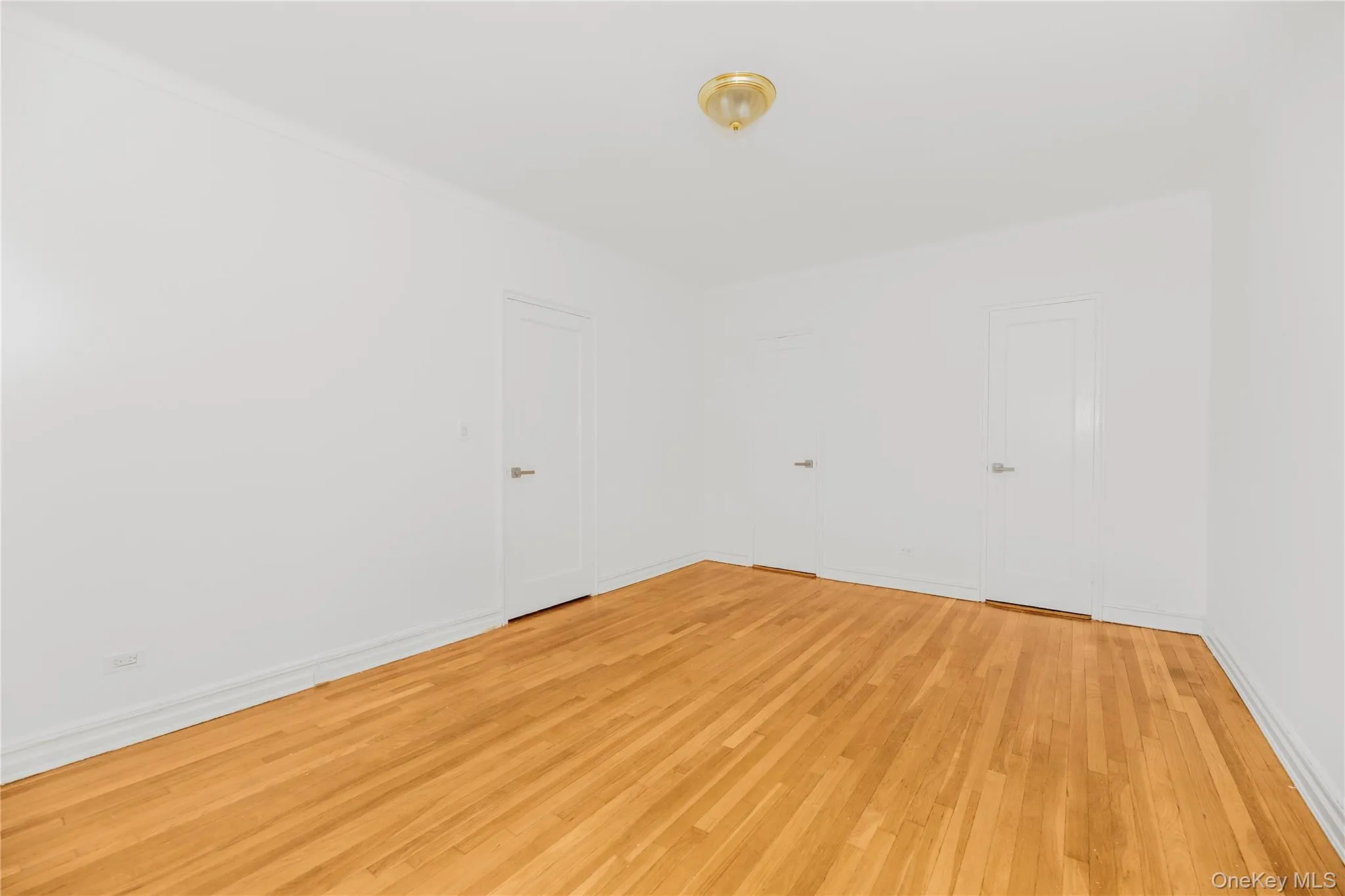 Empty room featuring light wood-style floors and baseboards Empty room featuring light wood-style floors and baseboards