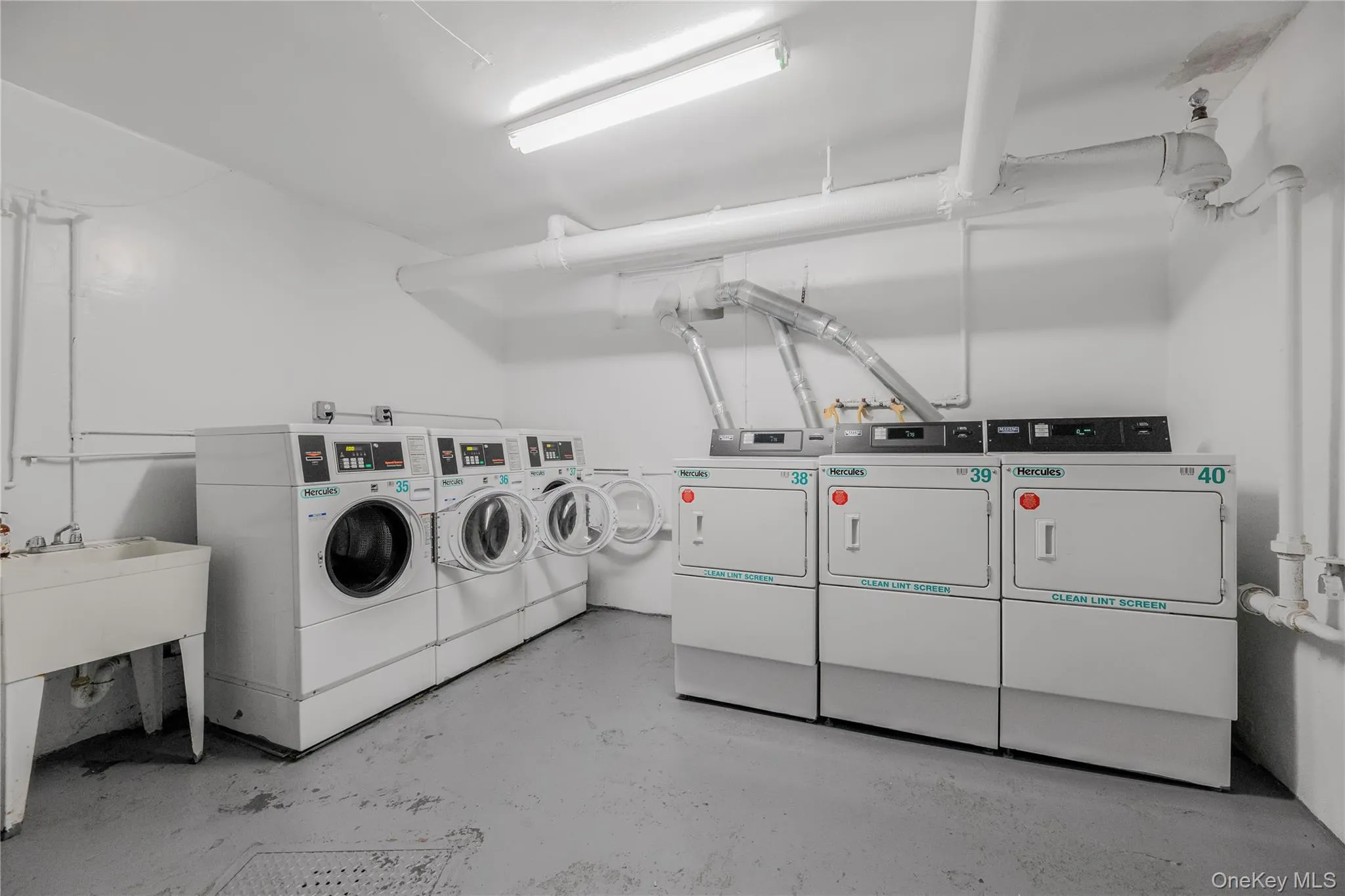 Community laundry room with washing machine and dryer Community laundry room with washing machine and dryer