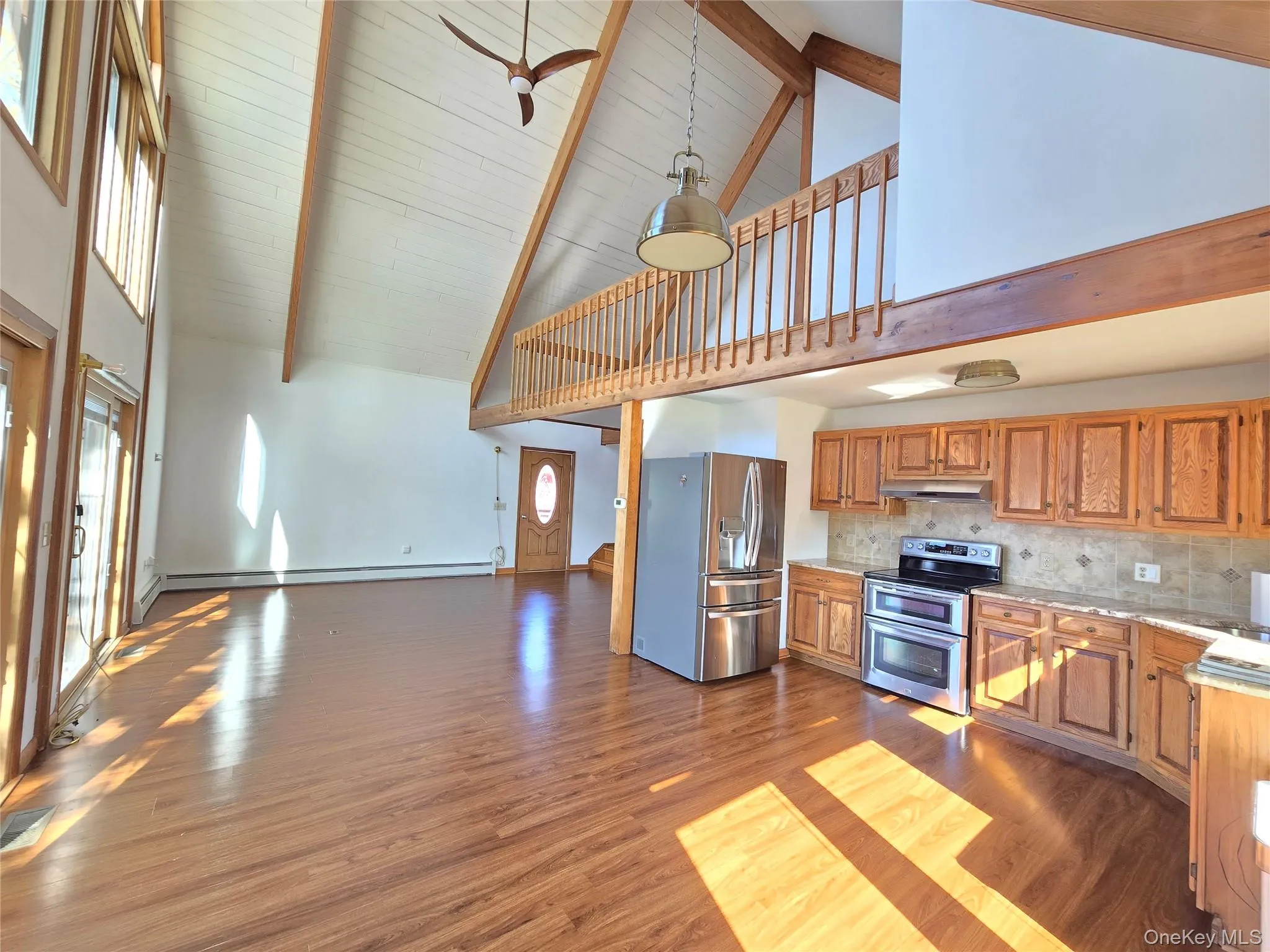Vaulted ceiling with exposed wood beams and wood-finish flooring Vaulted ceiling with exposed wood beams and wood-finish flooring