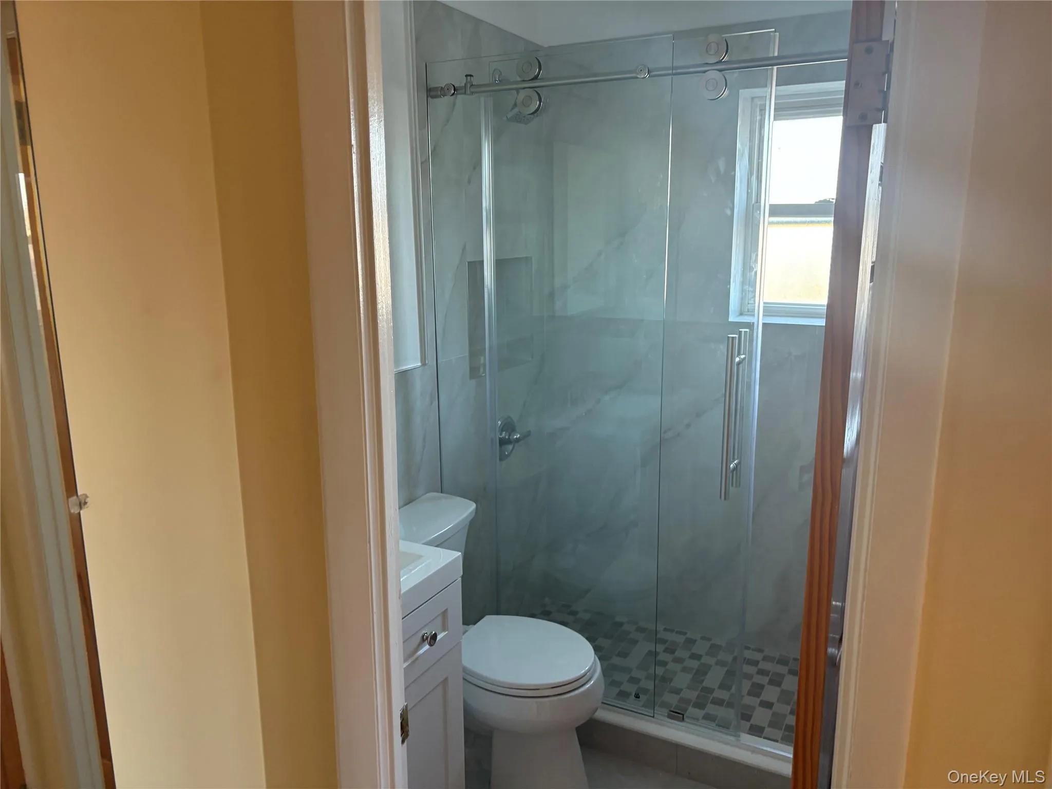 Primary hall Bathroom with vanity and a marble finish Primary hall Bathroom with vanity and a marble finish