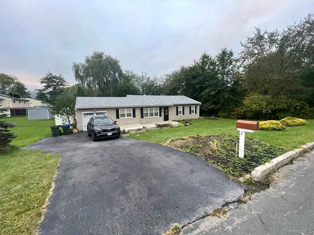 Ranch-style house with aphalt driveway, a garage, and a front lawn Ranch-style house with aphalt driveway, a garage, and a front lawn