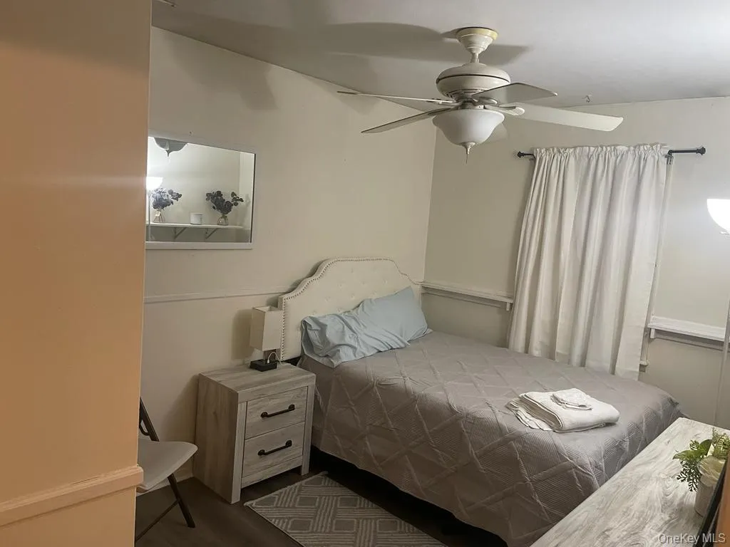 Bedroom featuring ceiling fan and wood finished floors Bedroom featuring ceiling fan and wood finished floors