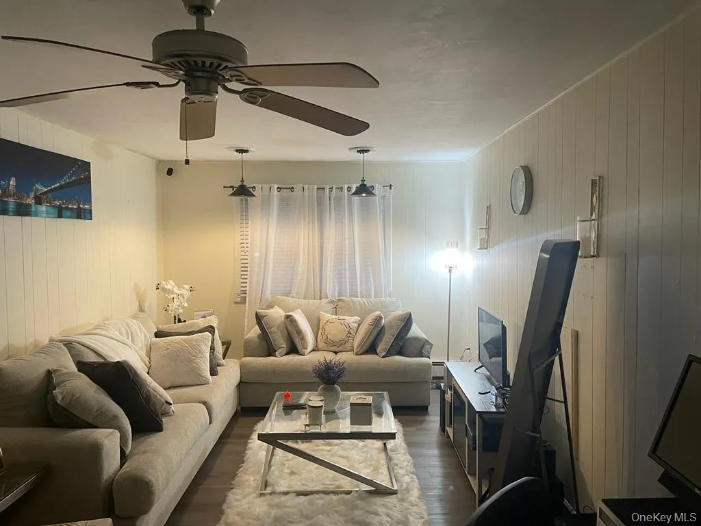 Living room featuring dark wood finished floors and ceiling fan Living room featuring dark wood finished floors and ceiling fan