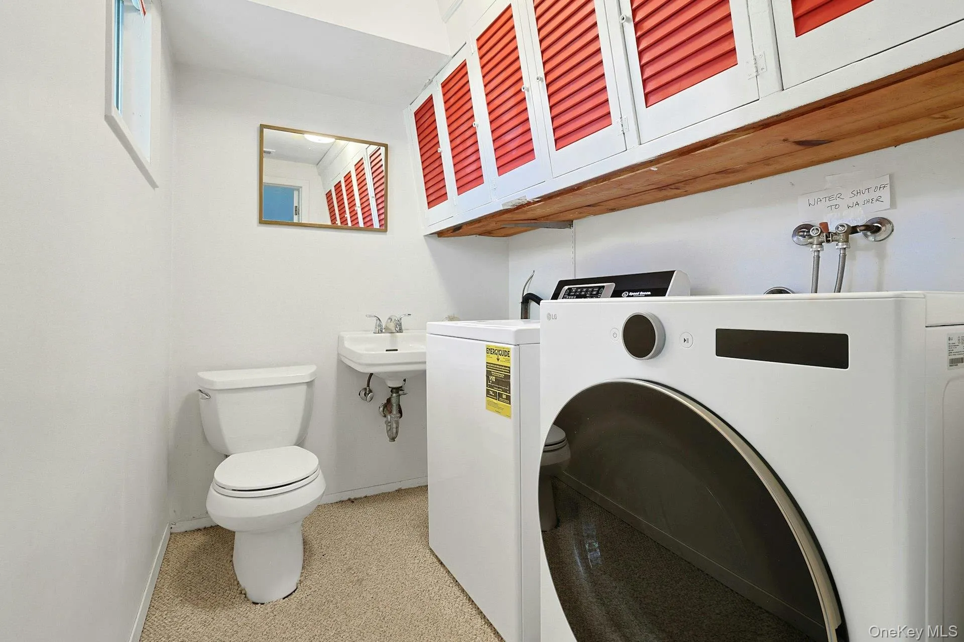 Half bath with washer & dryer & storage cabinets above Half bath with washer & dryer & storage cabinets above