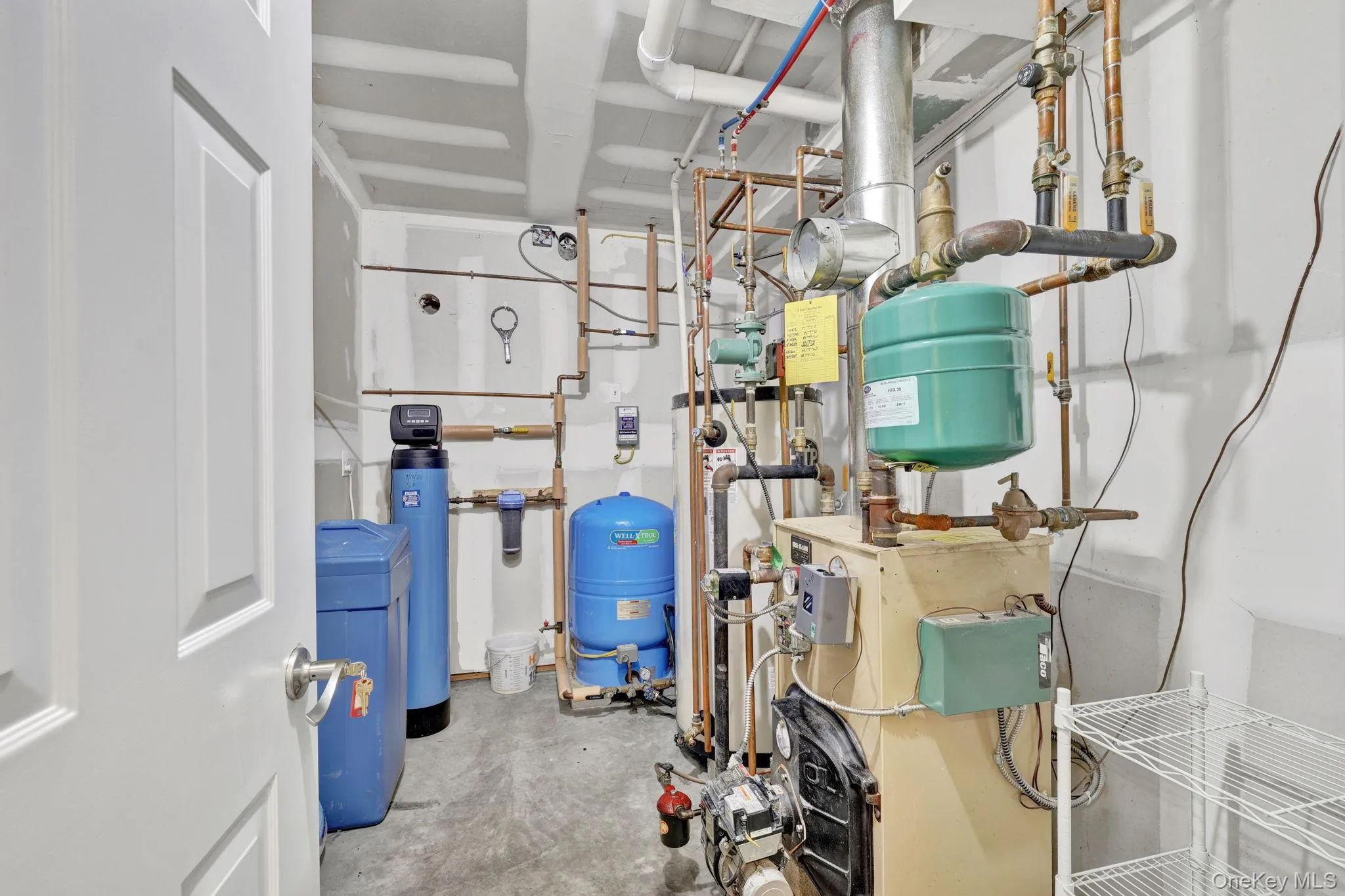Utility area featuring a water filtration system, water softener, and boiler with exposed copper piping. All meticulously maintained Utility area featuring a water filtration system, water softener, and boiler with exposed copper piping. All meticulously maintained
