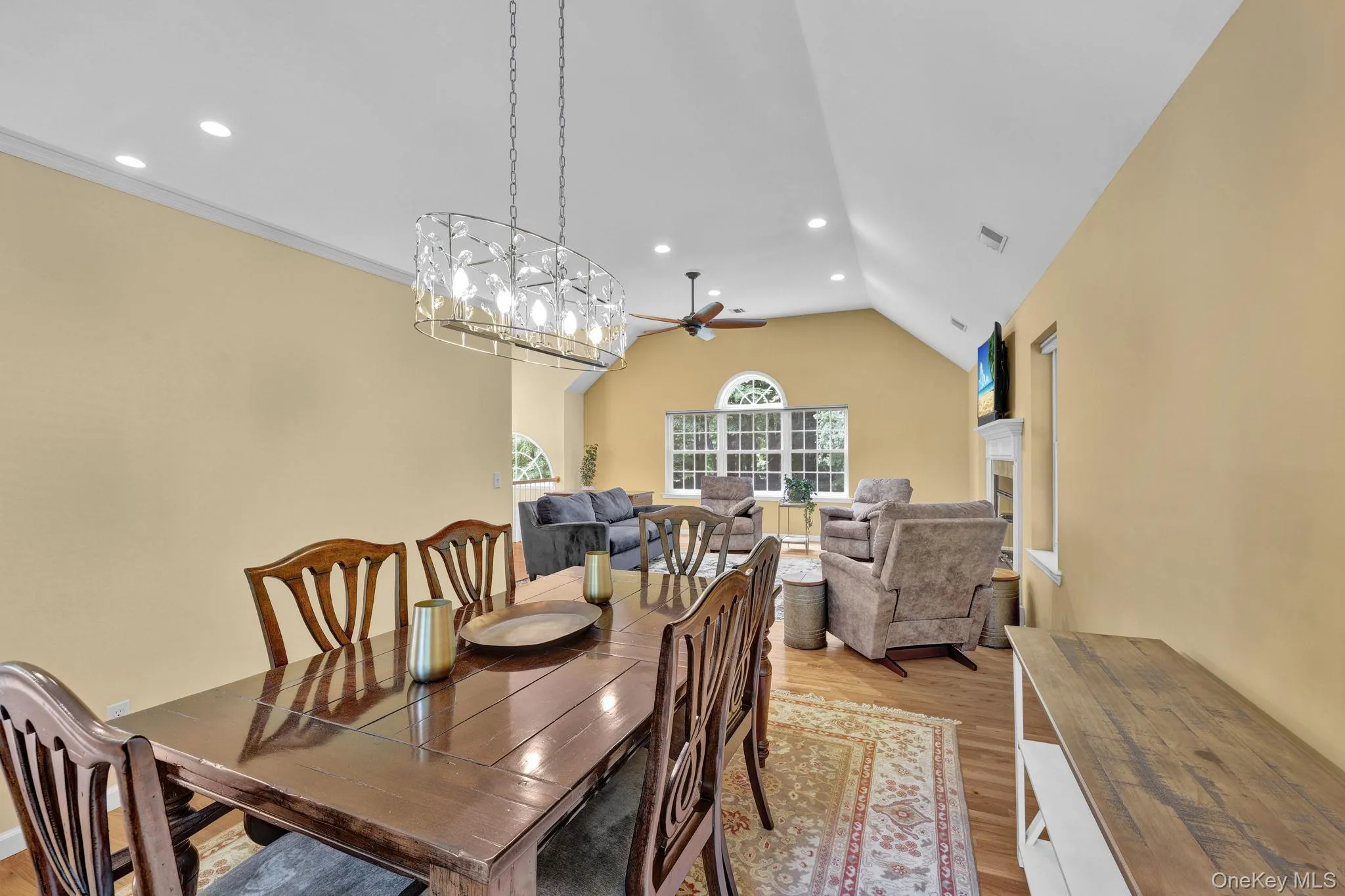 Dining area with wood-finish flooring and a contemporary chandelier Dining area with wood-finish flooring and a contemporary chandelier