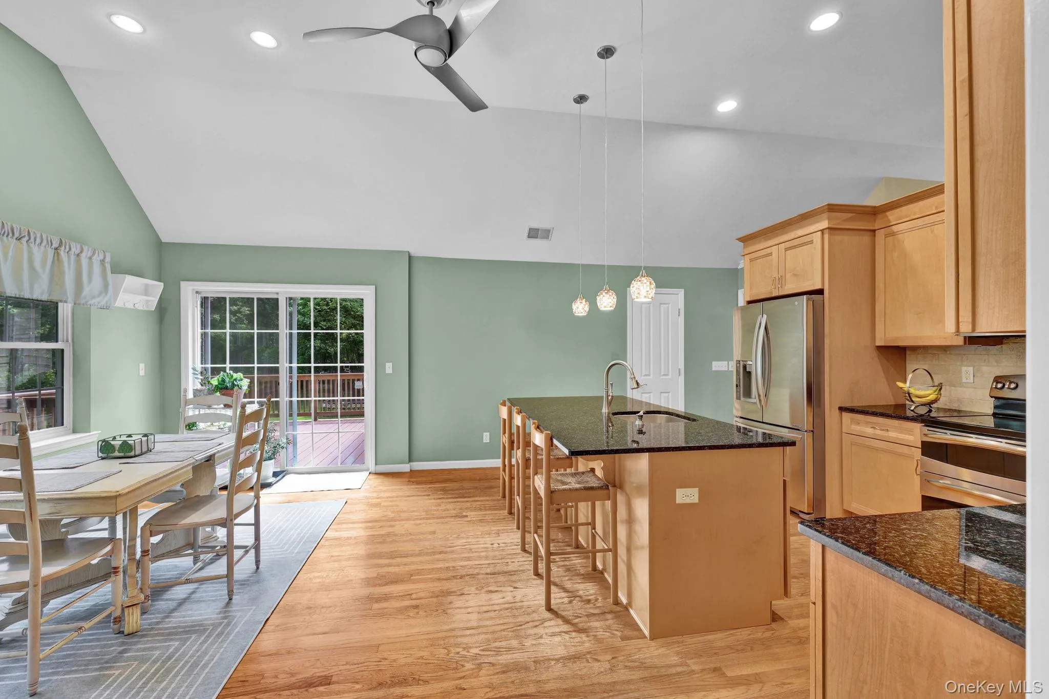 Open concept eat-in-kitchen with a vaulted ceiling and recessed lighting and sliding doors to your deck. Entertaining perfection! Open concept eat-in-kitchen with a vaulted ceiling and recessed lighting and sliding doors to your deck. Entertaining perfection!