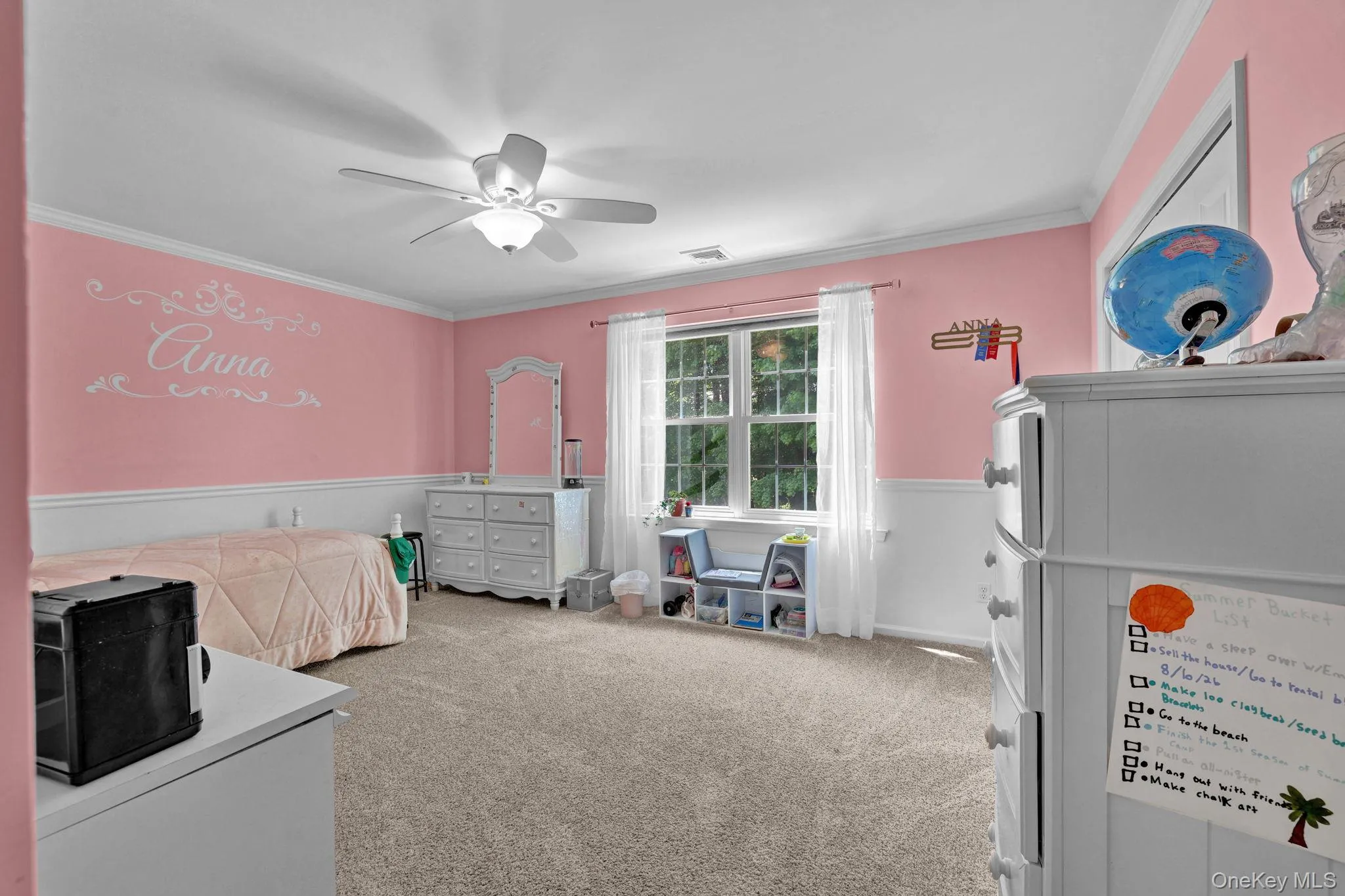 Spacious second room featuring a ceiling fan with integrated lighting, crown molding, and a large window with white trim Spacious second room featuring a ceiling fan with integrated lighting, crown molding, and a large window with white trim