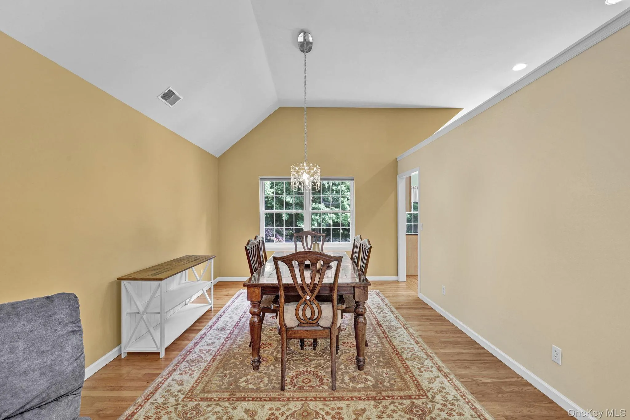 Dining area featuring vaulted ceilings, a window, wood-finish flooring, and recessed lighting Dining area featuring vaulted ceilings, a window, wood-finish flooring, and recessed lighting