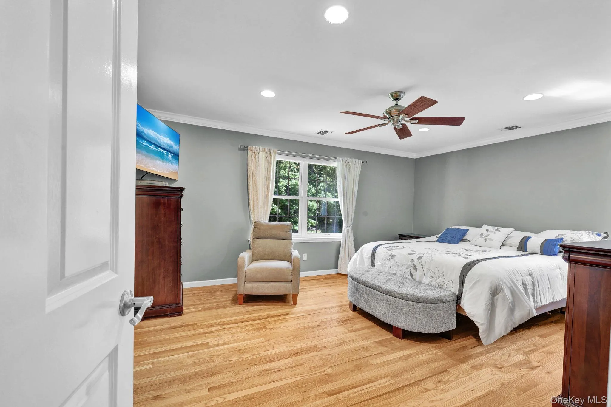 Large master bedroom featuring wood-finish flooring, recessed lighting, and a ceiling fan Large master bedroom featuring wood-finish flooring, recessed lighting, and a ceiling fan