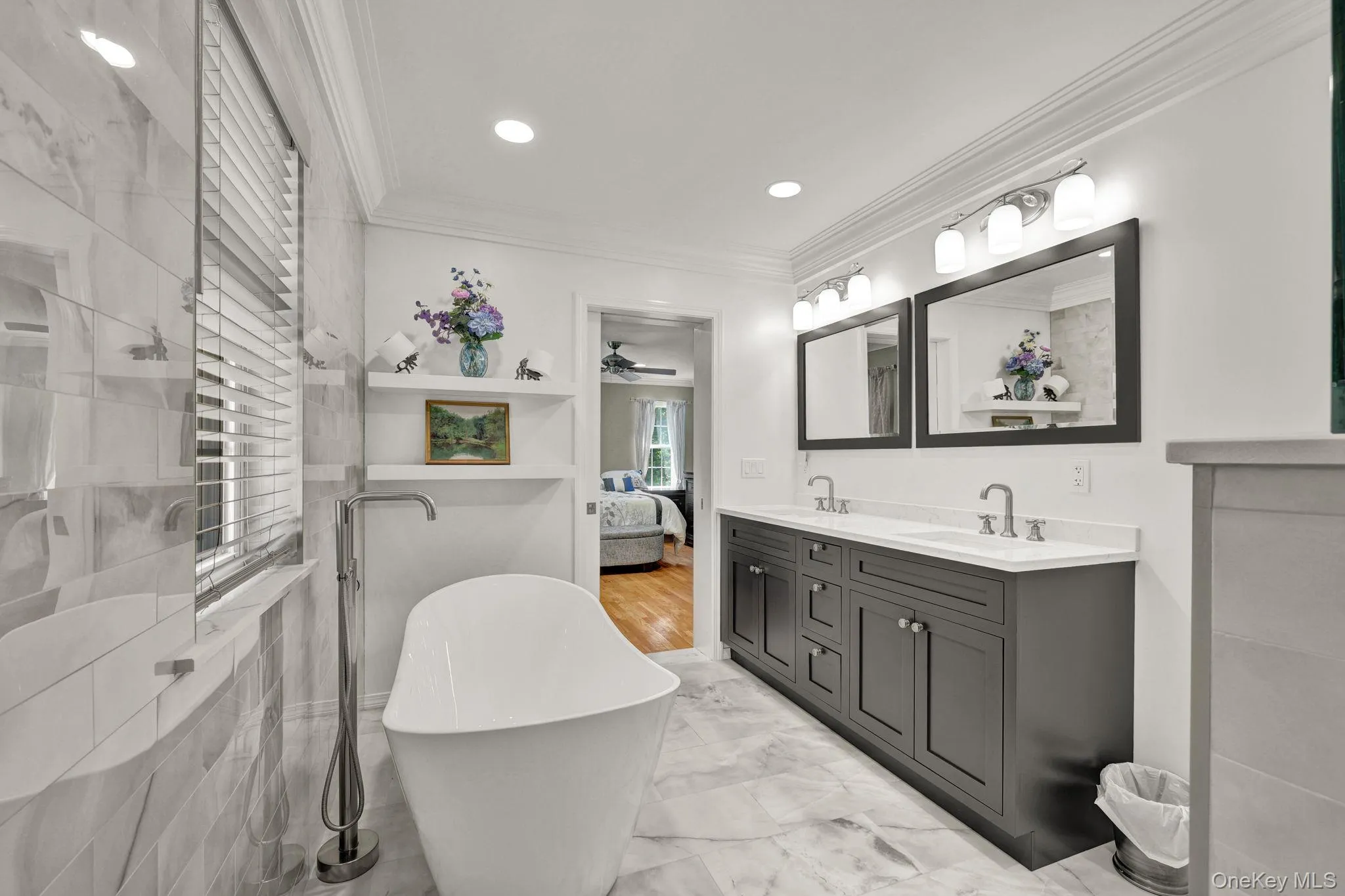 Freestanding soaking tub has floor-mounted faucet, complemented by marble-finish wall and floor tiling Freestanding soaking tub has floor-mounted faucet, complemented by marble-finish wall and floor tiling