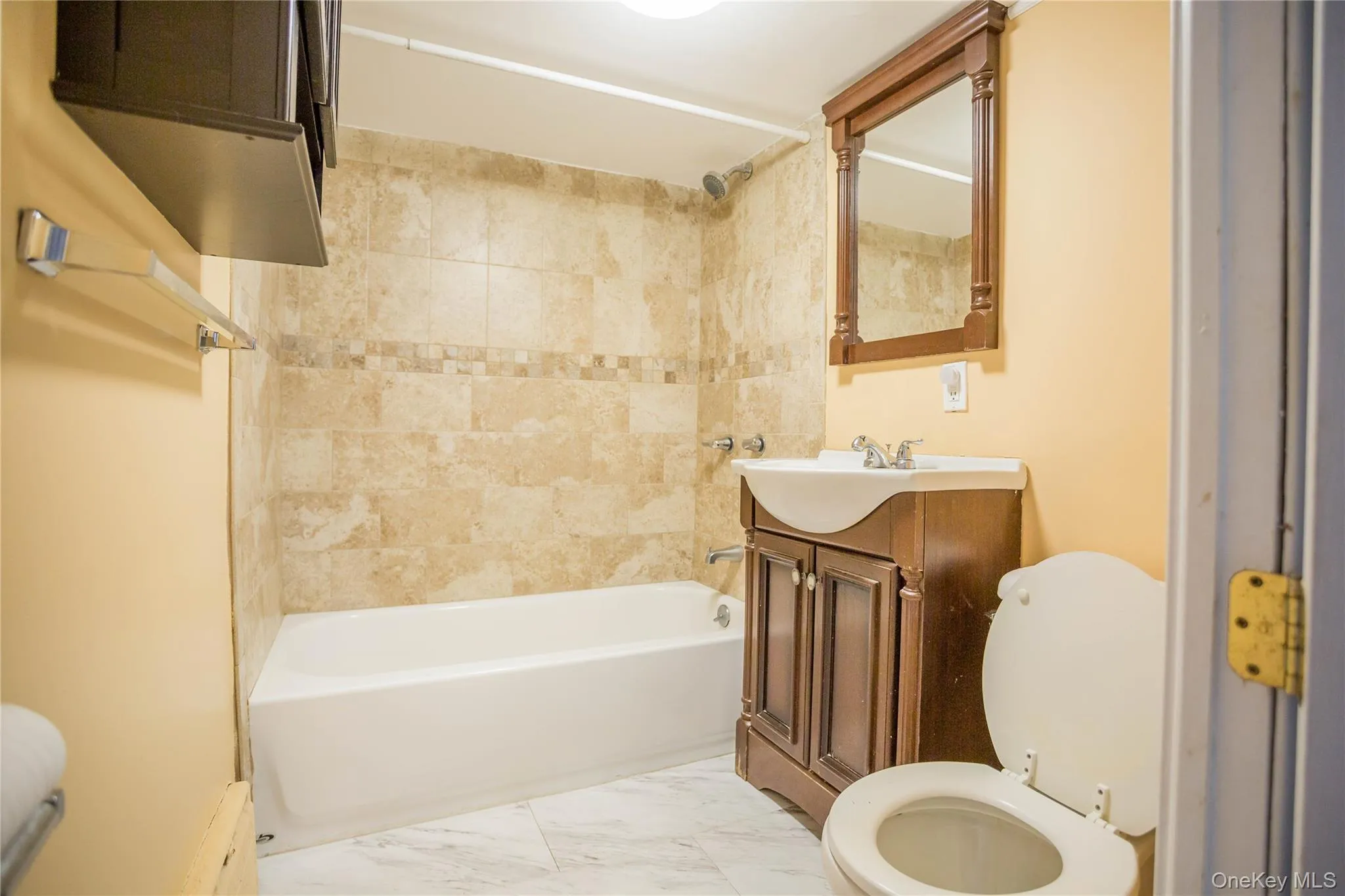 Full bathroom with marble finish floor, vanity, bathtub / shower combination, and toilet Full bathroom with marble finish floor, vanity, bathtub / shower combination, and toilet