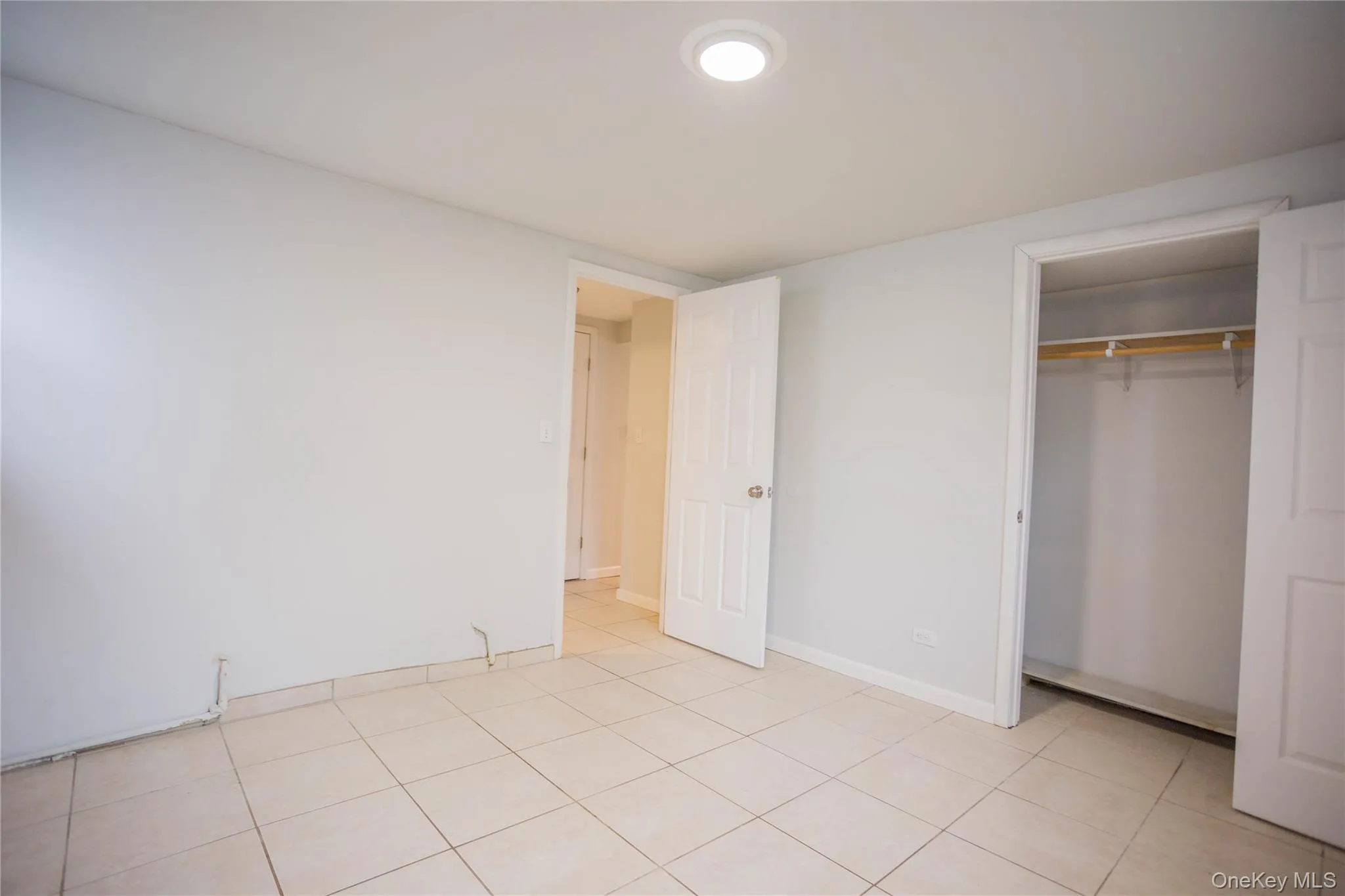 Unfurnished bedroom featuring a closet, baseboards, and light tile patterned flooring Unfurnished bedroom featuring a closet, baseboards, and light tile patterned flooring