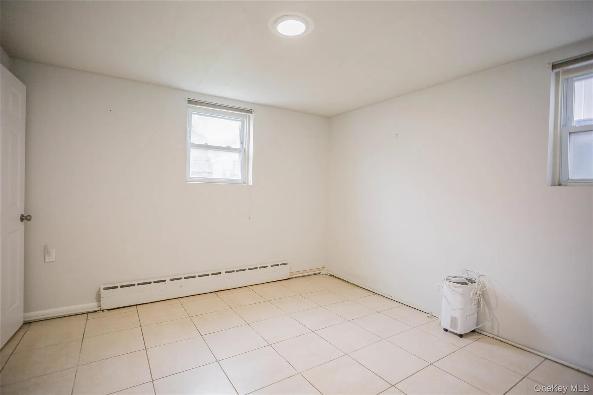 Spare room featuring a baseboard heating unit and a healthy amount of sunlight Spare room featuring a baseboard heating unit and a healthy amount of sunlight