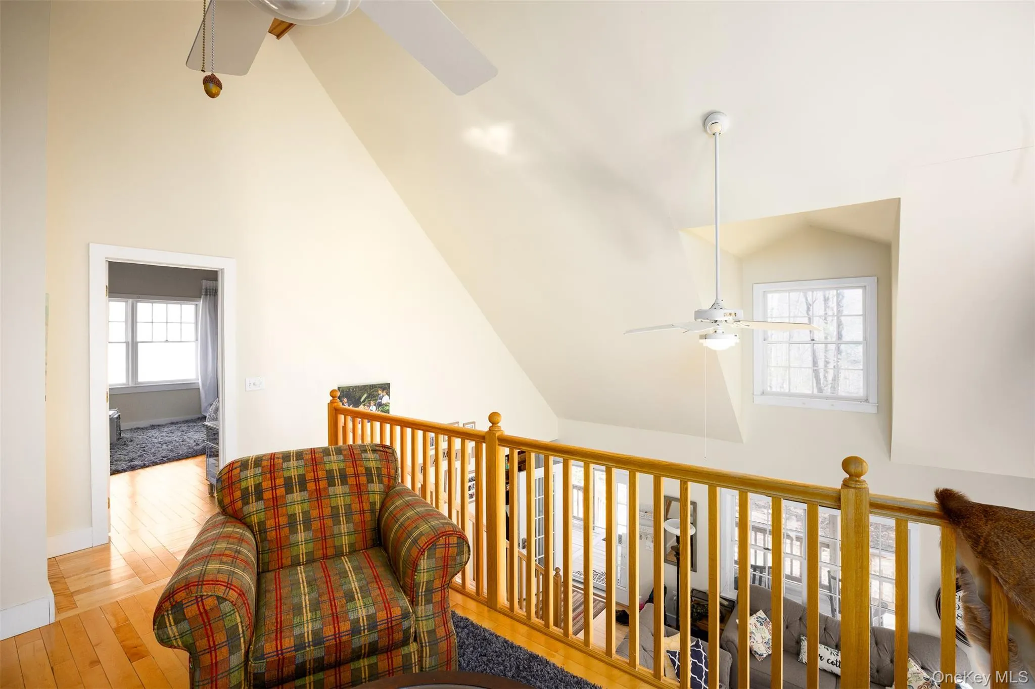 Sitting room featuring ceiling fan, light wood-style flooring, and lofted ceiling Sitting room featuring ceiling fan, light wood-style flooring, and lofted ceiling