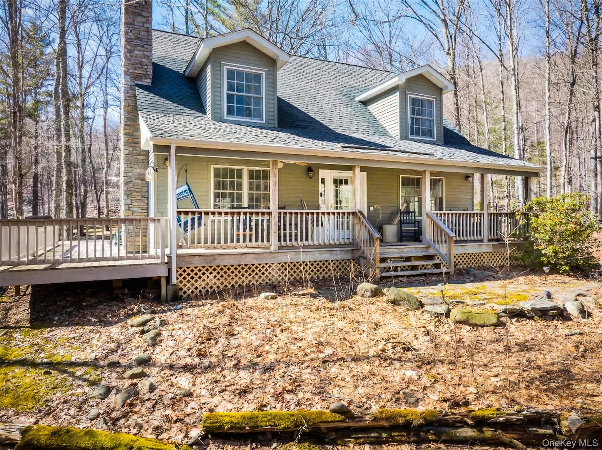 Cape cod home featuring roof with shingles, a porch, and a chimney Cape cod home featuring roof with shingles, a porch, and a chimney