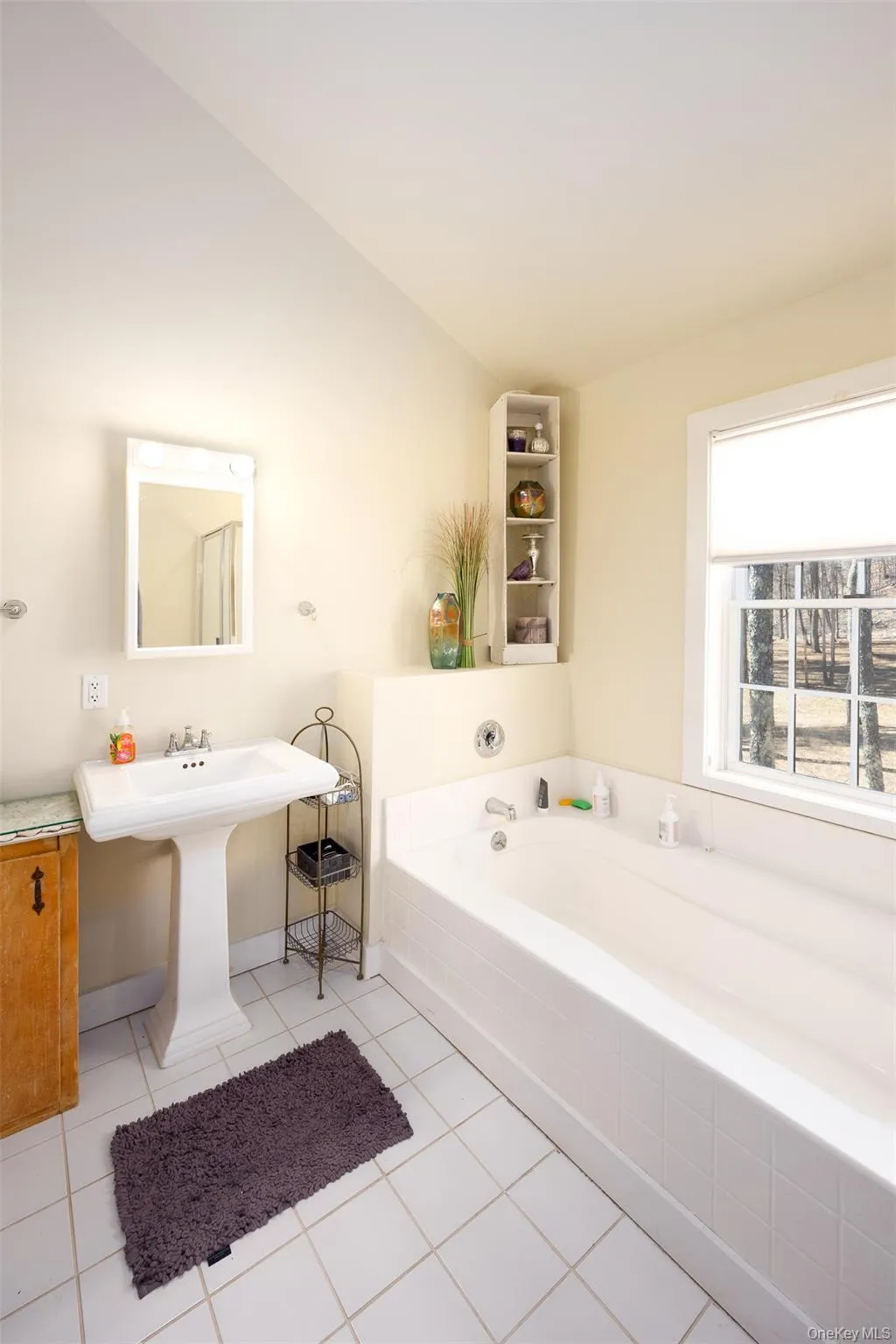 Full bathroom with a garden tub, vaulted ceiling, and light tile patterned floors Full bathroom with a garden tub, vaulted ceiling, and light tile patterned floors