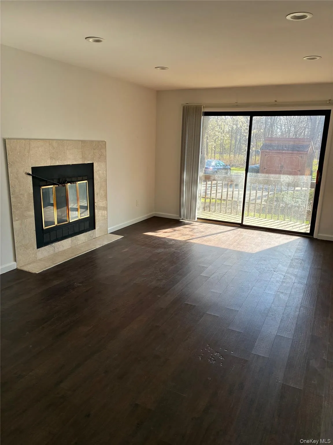 Large living room with fireplace and sliders to deck Large living room with fireplace and sliders to deck
