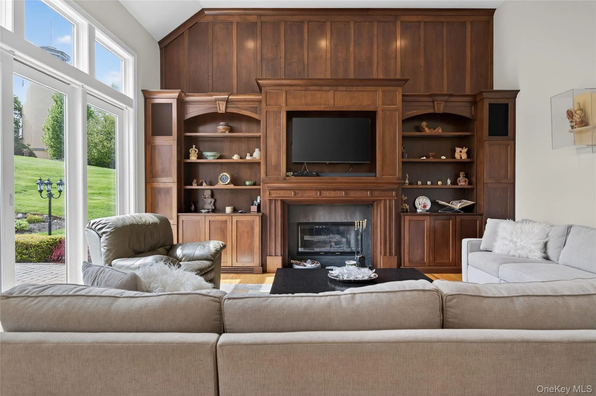 Den with oversized windows and sliding doors with built-in wood cabinetry and gas fireplace Den with oversized windows and sliding doors with built-in wood cabinetry and gas fireplace