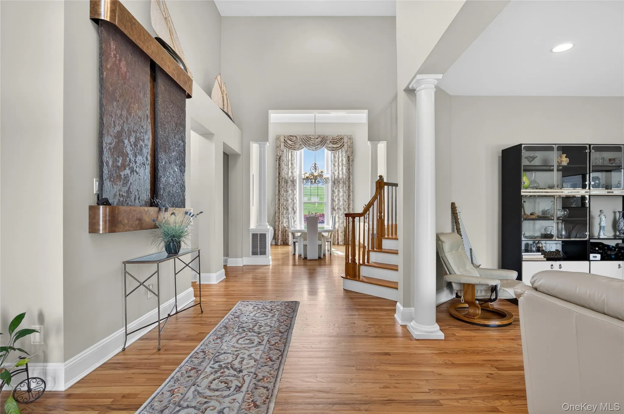 Foyer with high ceilings, hardwood flooring and a staircase Foyer with high ceilings, hardwood flooring and a staircase