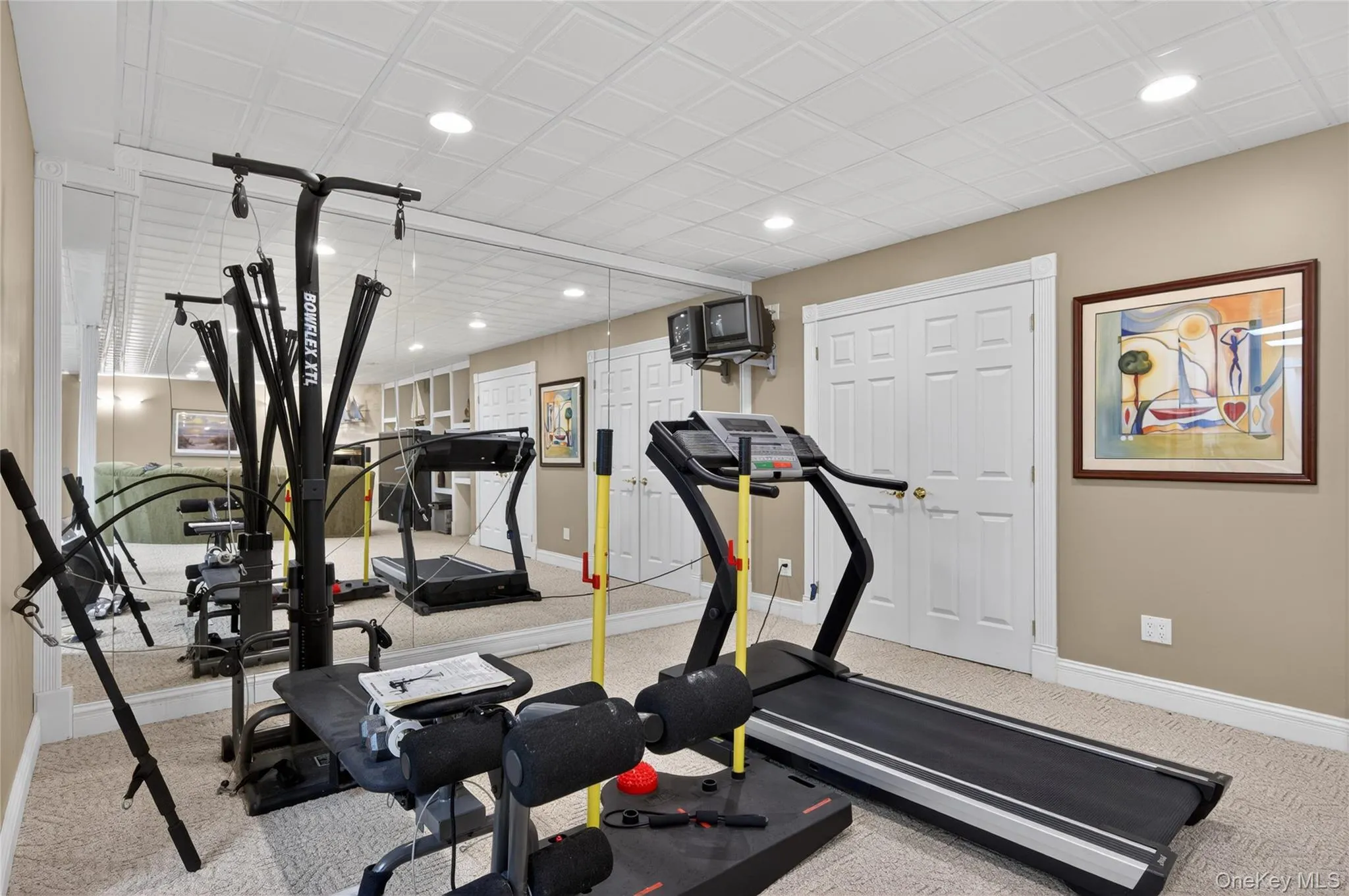 Spacious basement featuring full-wall mirrors and recessed lighting Spacious basement featuring full-wall mirrors and recessed lighting