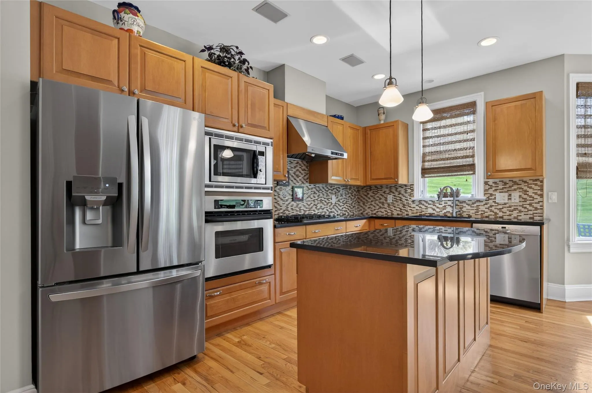 Kitchen featuring stainless steel appliances, center island and wood cabinetry Kitchen featuring stainless steel appliances, center island and wood cabinetry