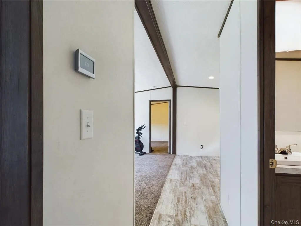 Hall featuring sink and light colored carpet Hall featuring sink and light colored carpet
