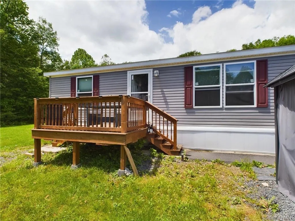 Rear view of property with a lawn and a deck Rear view of property with a lawn and a deck