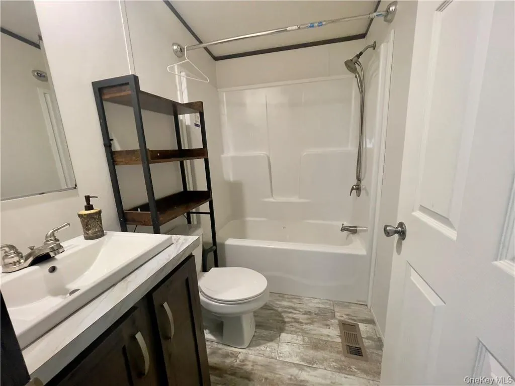 Full bathroom featuring tile floors, vanity, toilet, and tub / shower combination Full bathroom featuring tile floors, vanity, toilet, and tub / shower combination