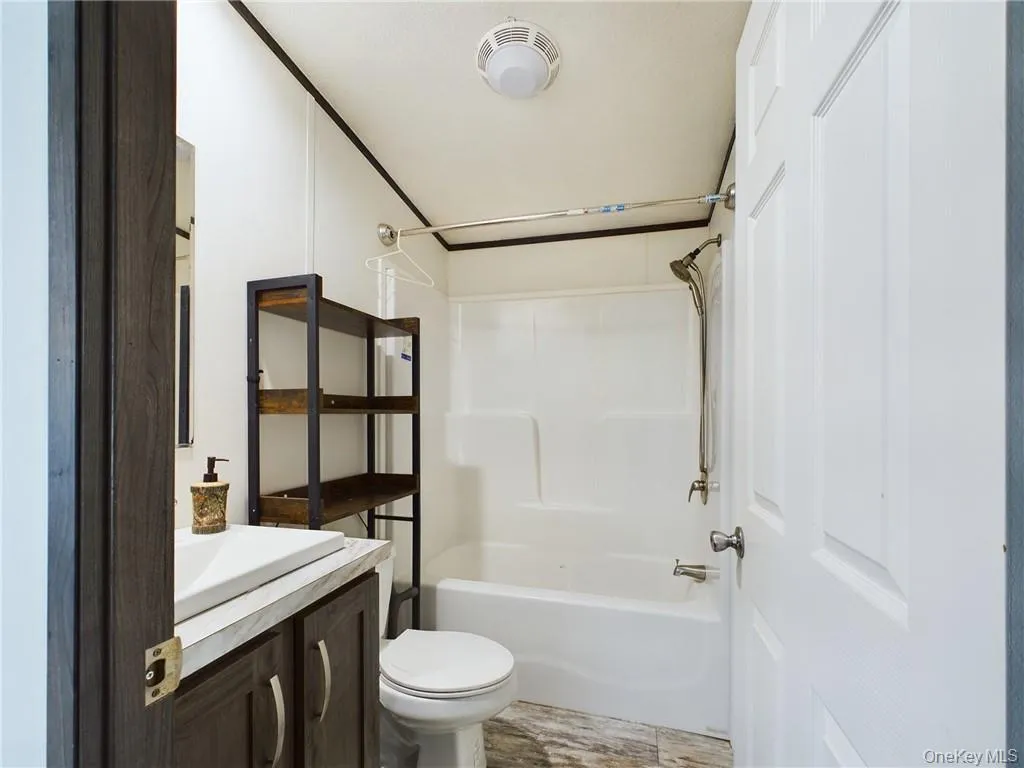 Full bathroom featuring bathtub / shower combination, vanity, and toilet Full bathroom featuring bathtub / shower combination, vanity, and toilet