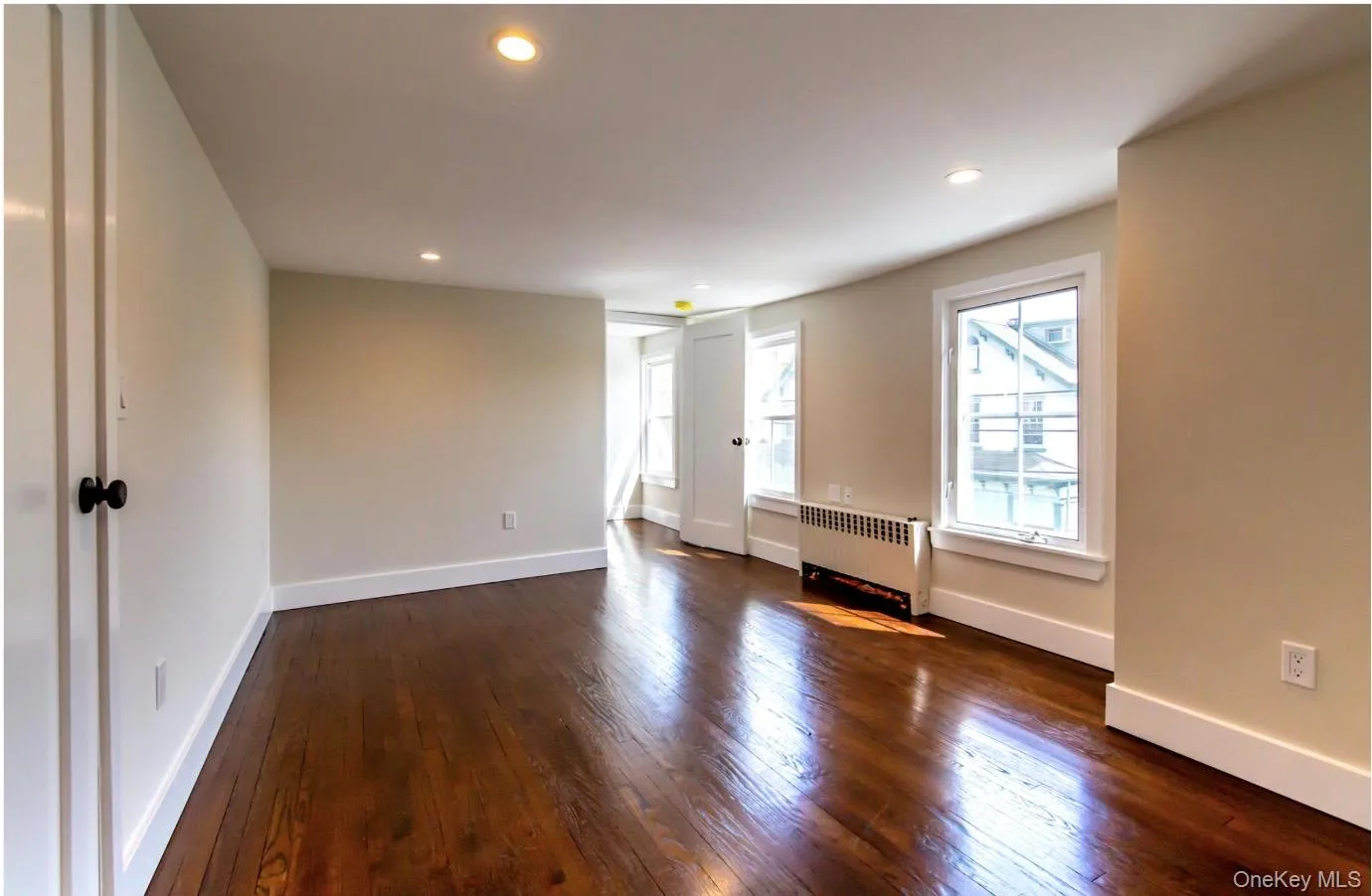 Unfurnished room with radiator, dark wood-type flooring, and recessed lighting Unfurnished room with radiator, dark wood-type flooring, and recessed lighting