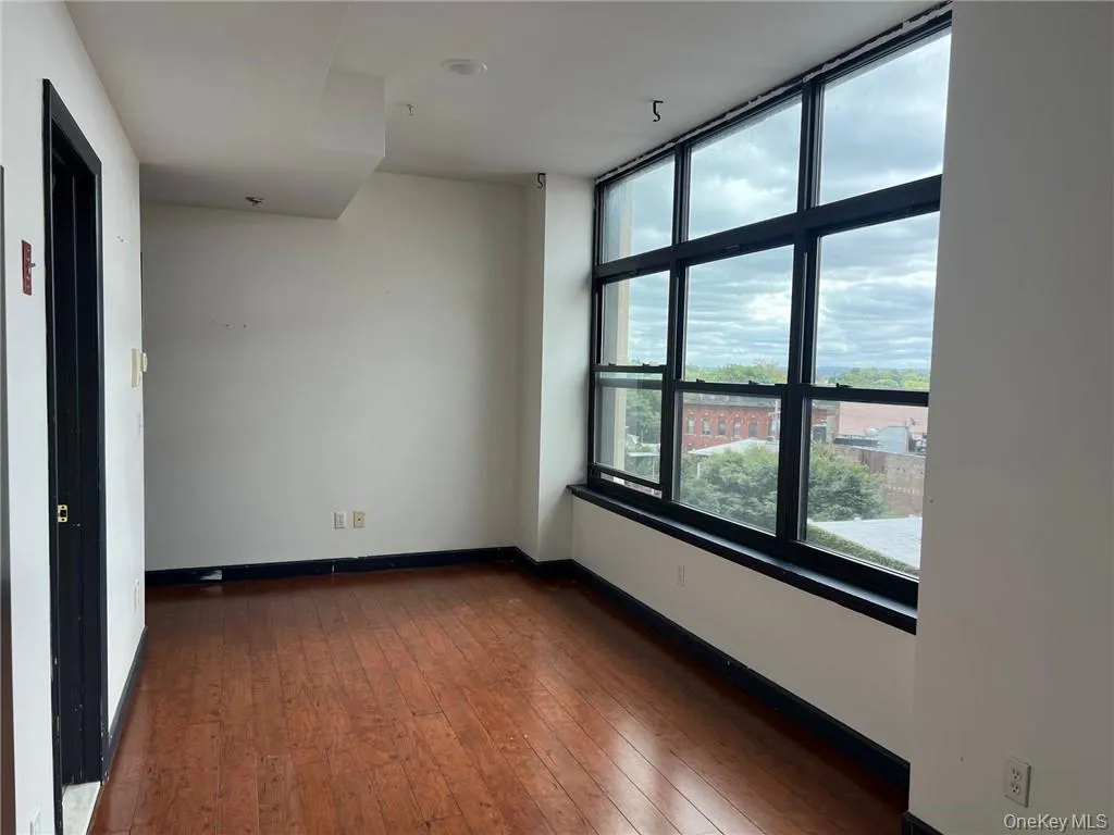 Empty room featuring dark hardwood / wood-style floors Empty room featuring dark hardwood / wood-style floors