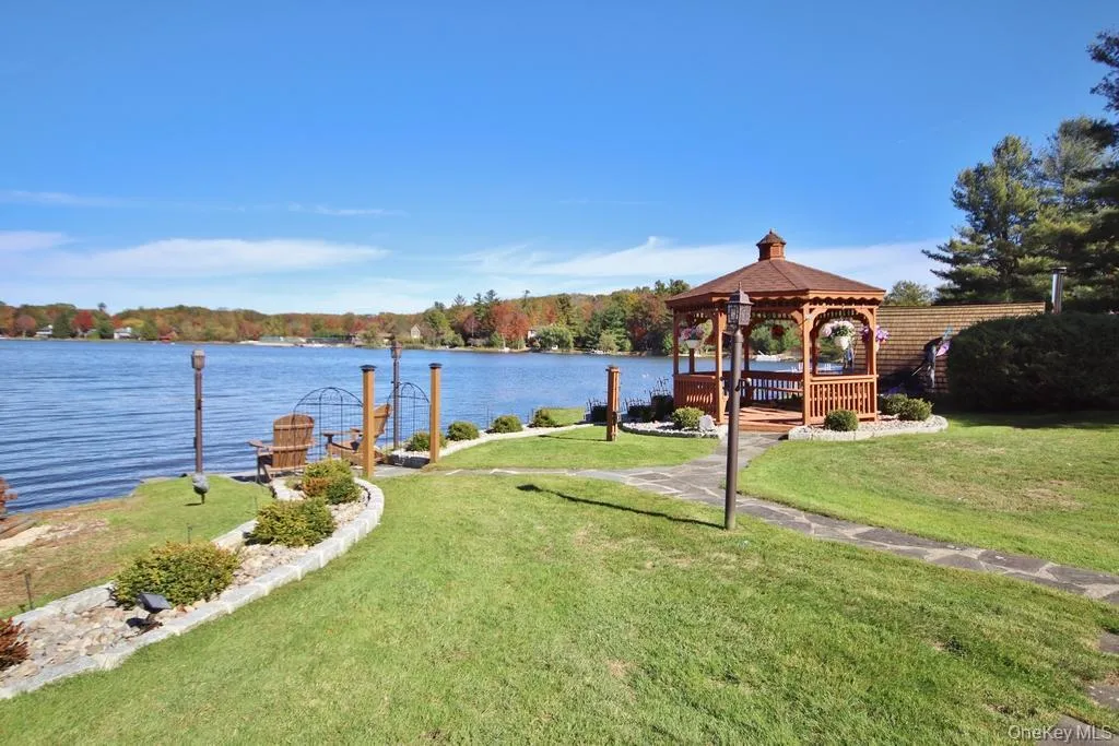 View of grassy yard with a gazebo and a deck with water view View of grassy yard with a gazebo and a deck with water view