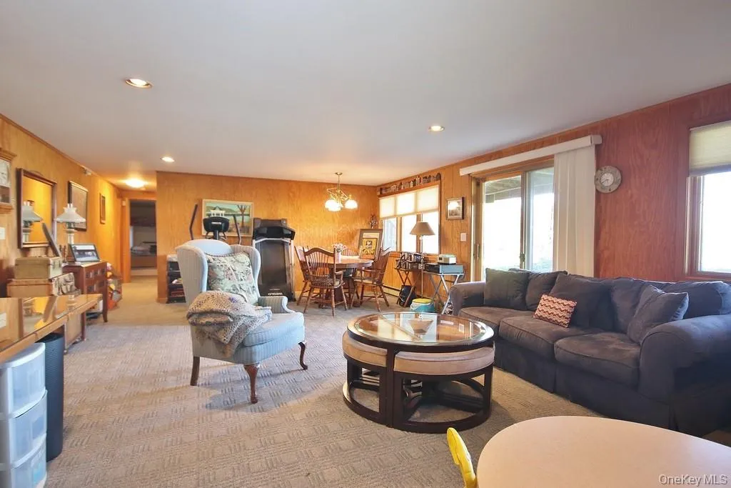 Living area with wood walls, a chandelier, carpet, and recessed lighting Living area with wood walls, a chandelier, carpet, and recessed lighting