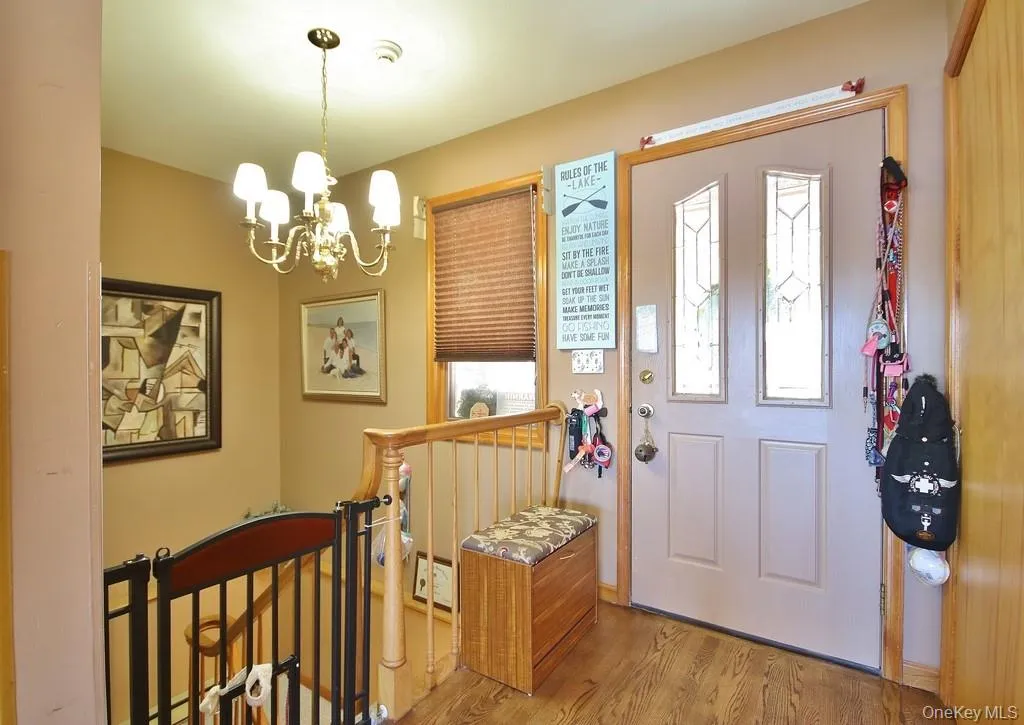 Entrance foyer featuring wood finished floors and a chandelier Entrance foyer featuring wood finished floors and a chandelier