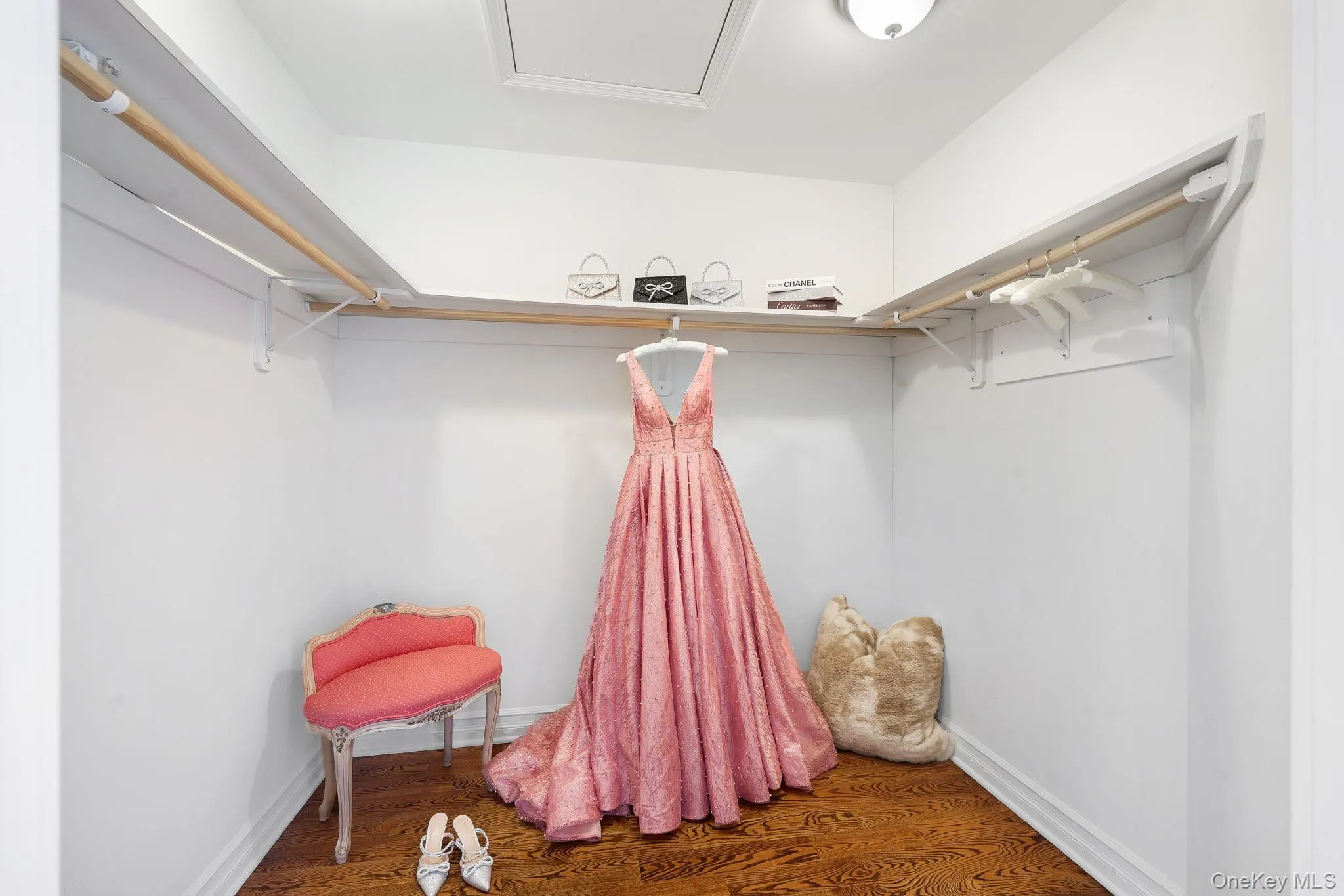 One of two oversized primary walk-in closets ,hardwood-finish flooring, built-in shelving, and hanging rods One of two oversized primary walk-in closets ,hardwood-finish flooring, built-in shelving, and hanging rods