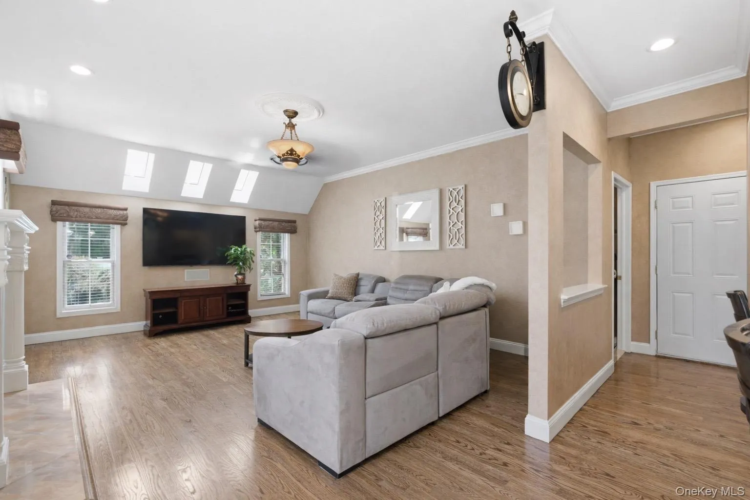 This spacious living room features hardwood floors, a vaulted ceiling with skylights, This spacious living room features hardwood floors, a vaulted ceiling with skylights,
