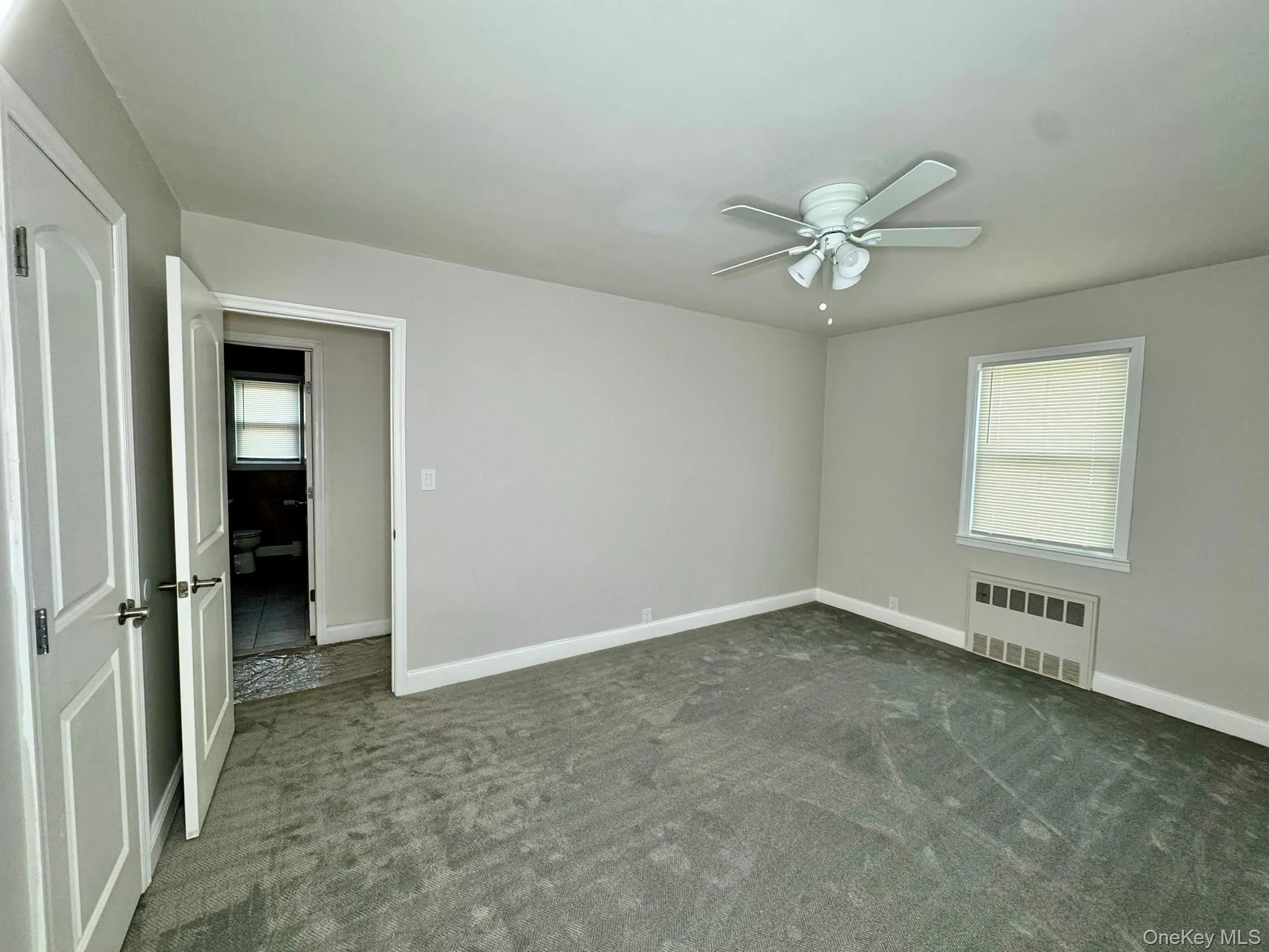 room with carpet, radiator heating unit, and ceiling fan room with carpet, radiator heating unit, and ceiling fan