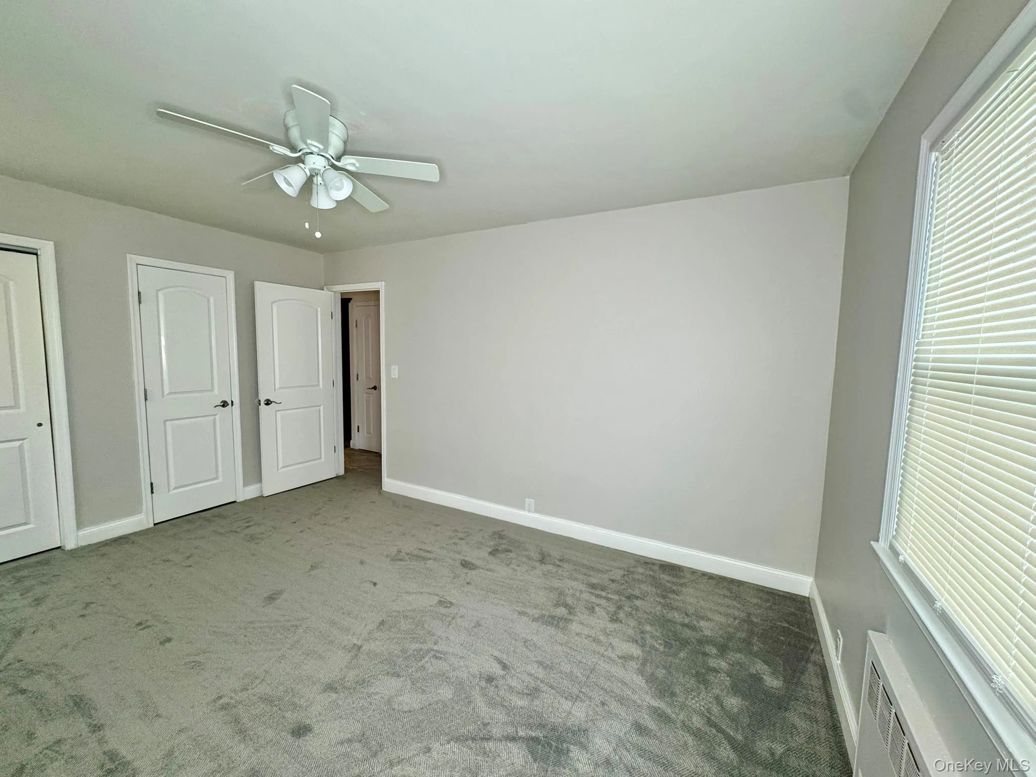 Unfurnished bedroom featuring a ceiling fan, carpet flooring, and 2 closet Unfurnished bedroom featuring a ceiling fan, carpet flooring, and 2 closet