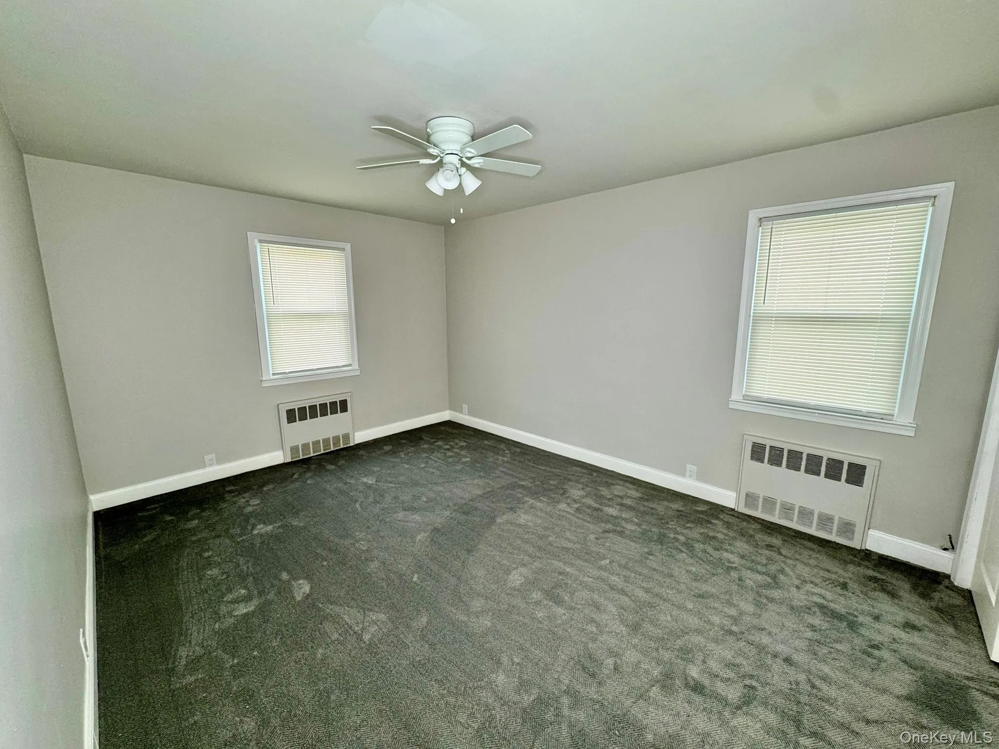 room with carpet, ceiling fan, and radiator heating unit room with carpet, ceiling fan, and radiator heating unit