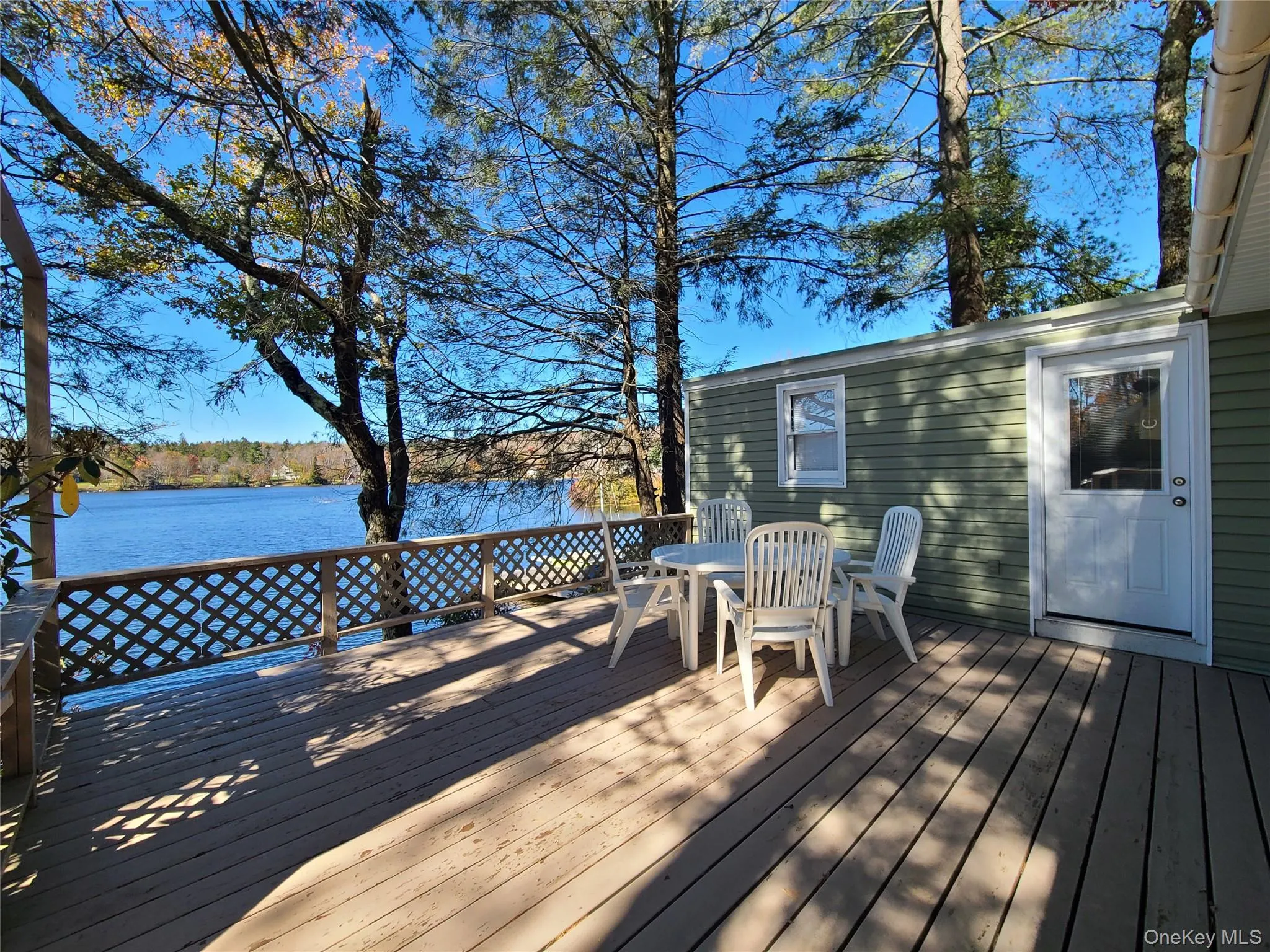 Wooden deck featuring outdoor dining area and a water view Wooden deck featuring outdoor dining area and a water view