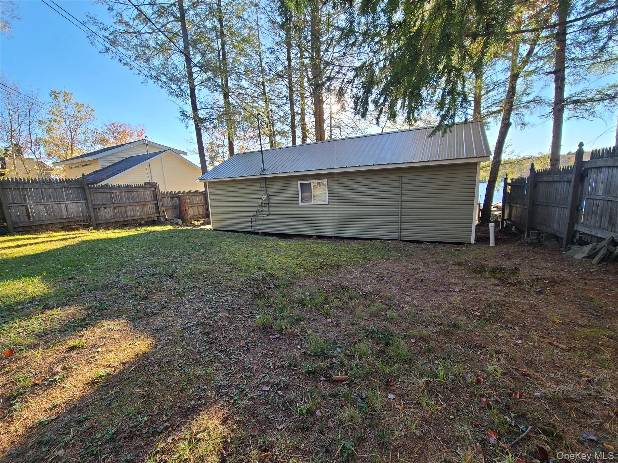 Rear view of property featuring a fenced backyard and a metal roof Rear view of property featuring a fenced backyard and a metal roof